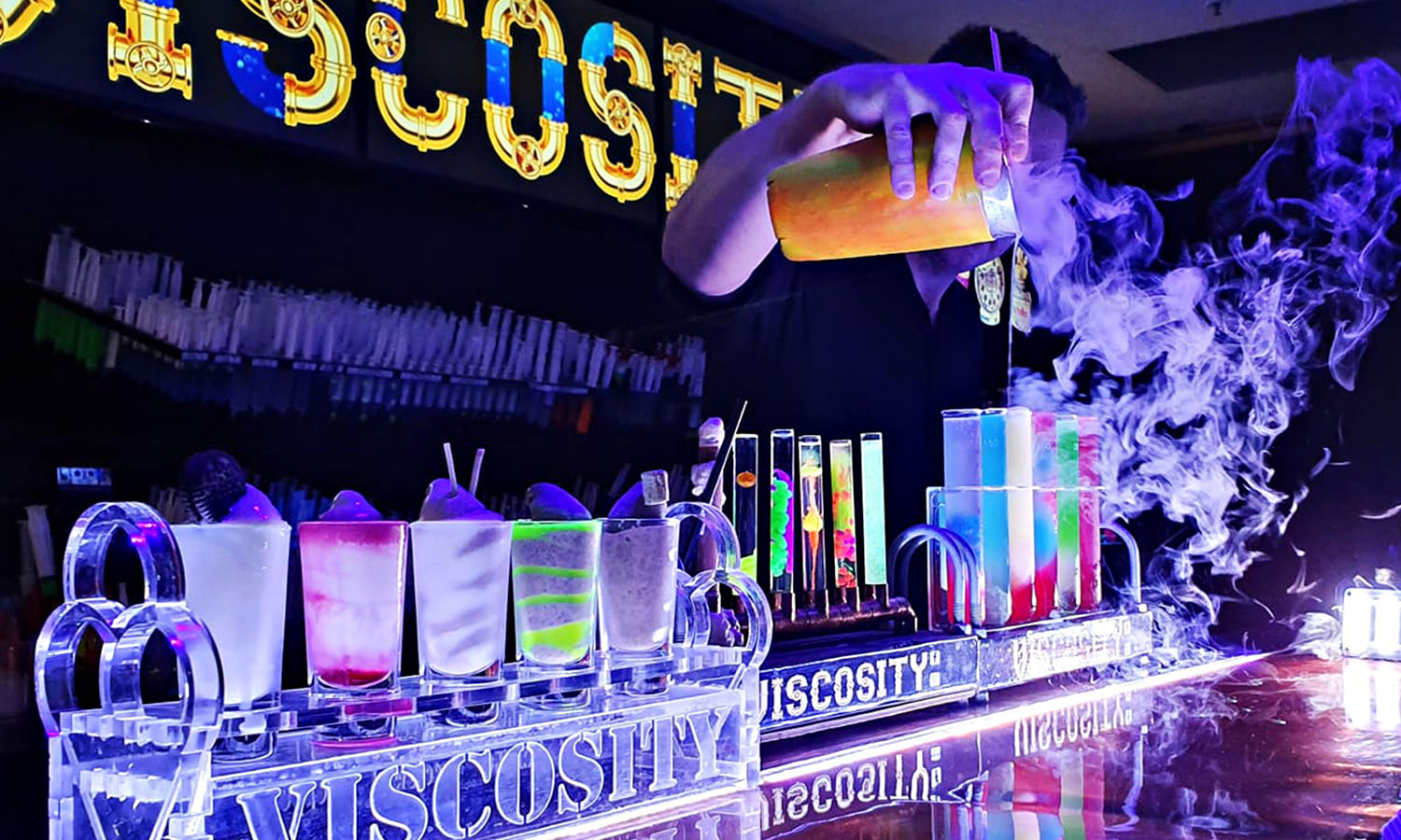 A man pours smoky cocktails behind the bar at Viscosity in Brisbane.