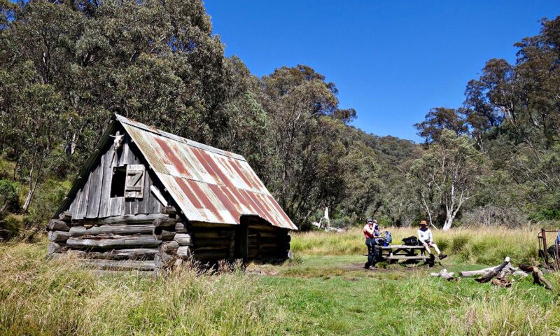 A group of people taking a snack break at the abandoned Dibbins Hut.