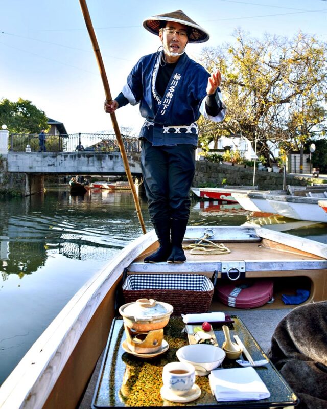 A gondola boatman gestures to his passengers in Yanagawa.