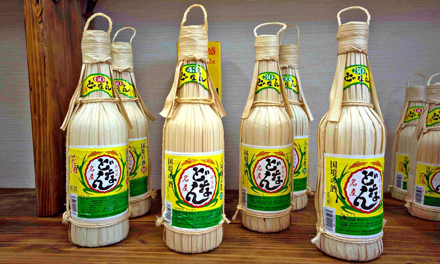 A group of bottles of Hanasake stand on a shelf.