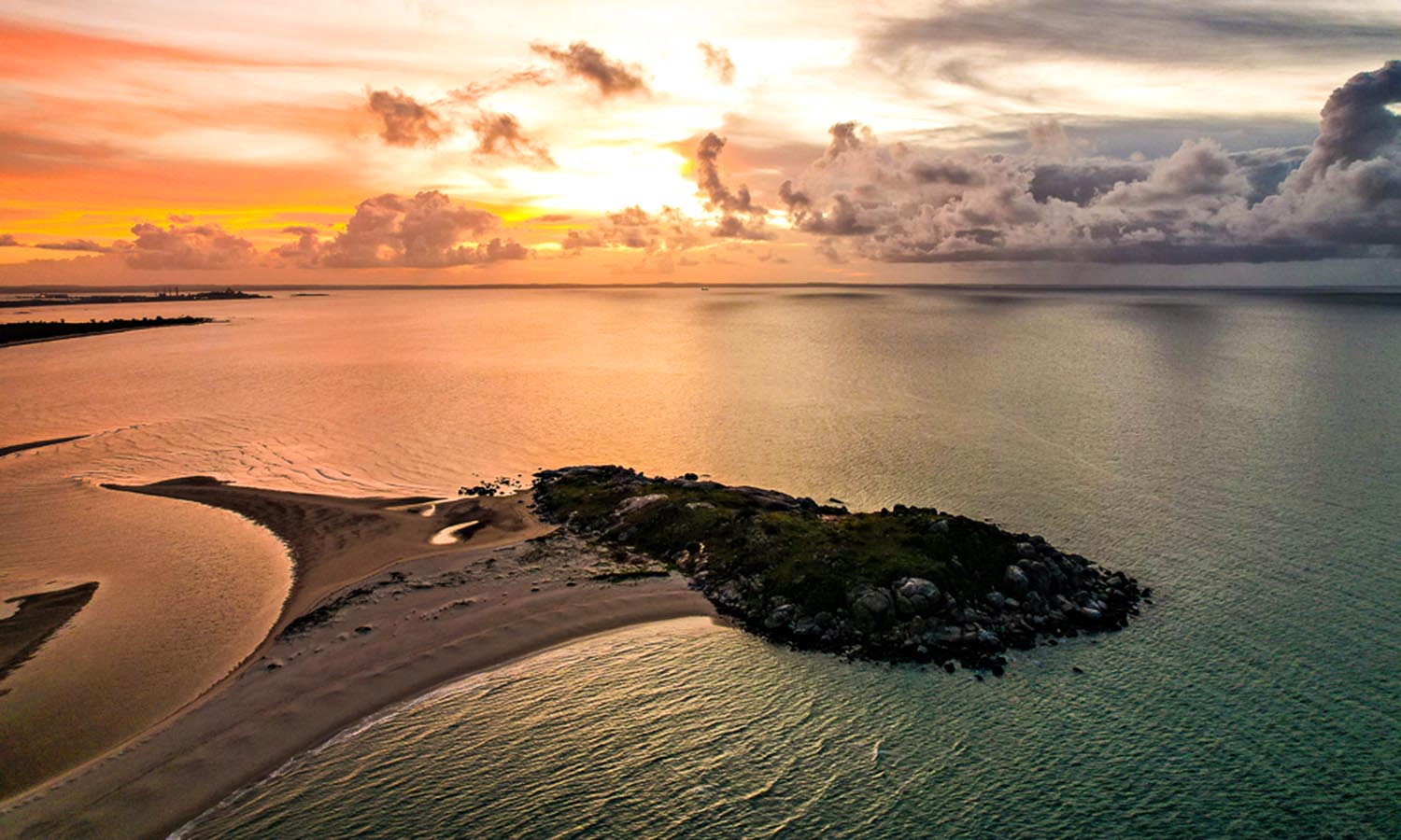 A small stretch of sand jutting out from the mainland of Arnhem Land at sunset.