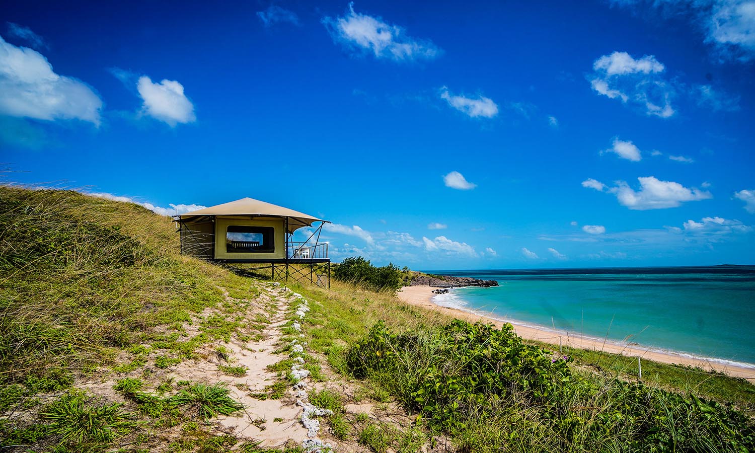 A tent used for accommodation a grassy sand dune overlooking the water on Bremer Island.