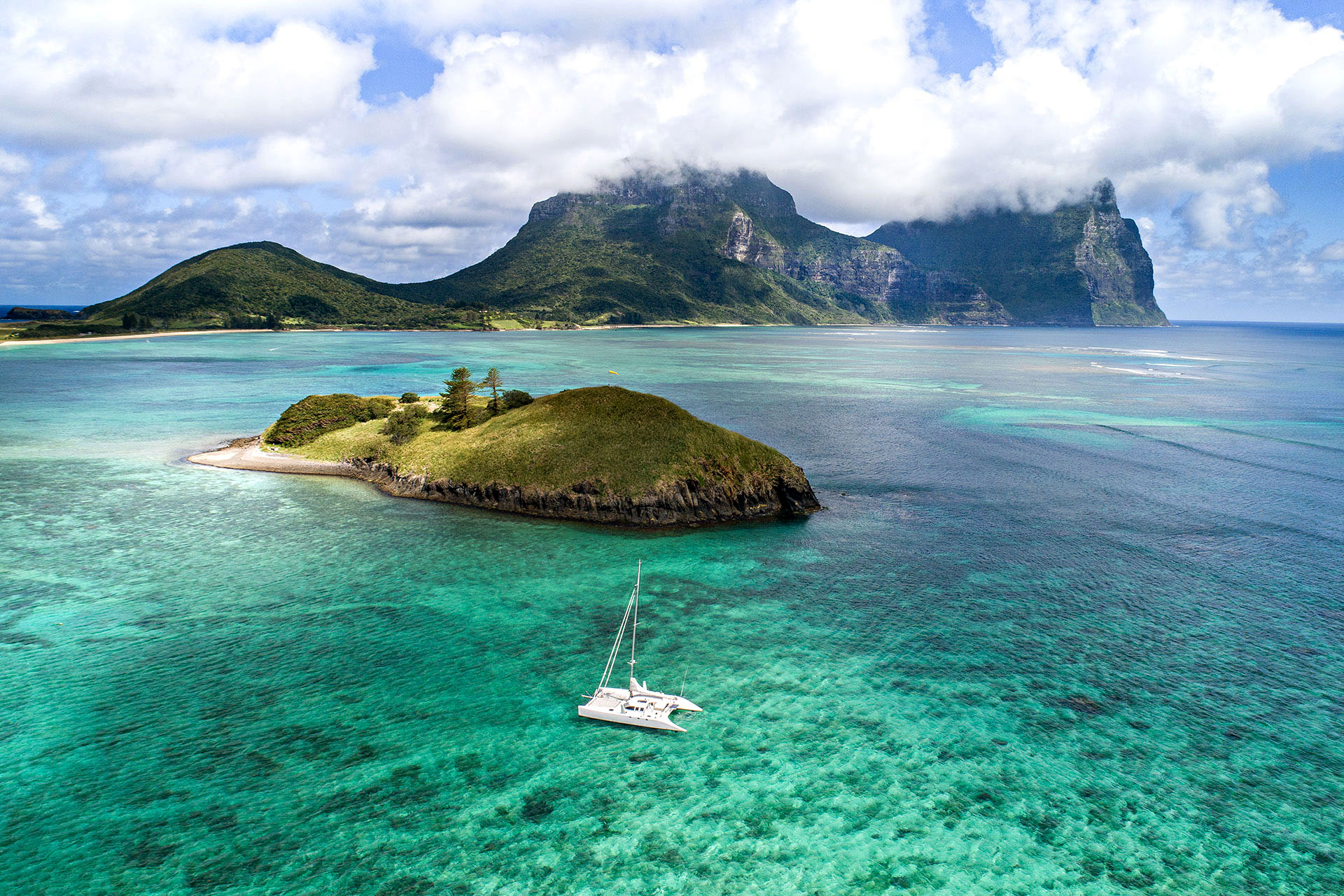 A boat sailing the turquoise waters of Lord Howe Island.
