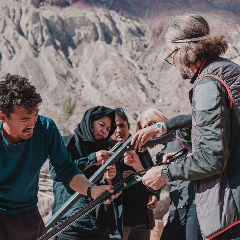 A group of people are attempting to figure out how to install a heater in the Ladakh Ranges.
