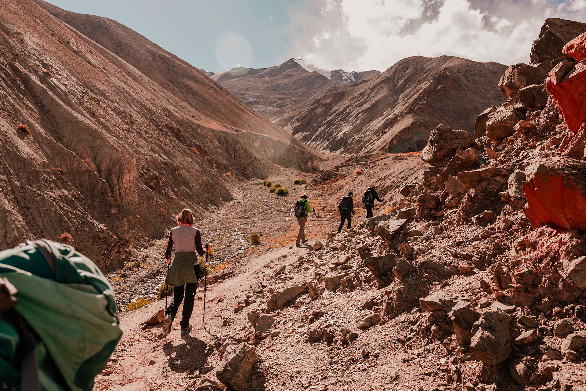 A group of hikers walk between the rocky mountains of Kathmandu.