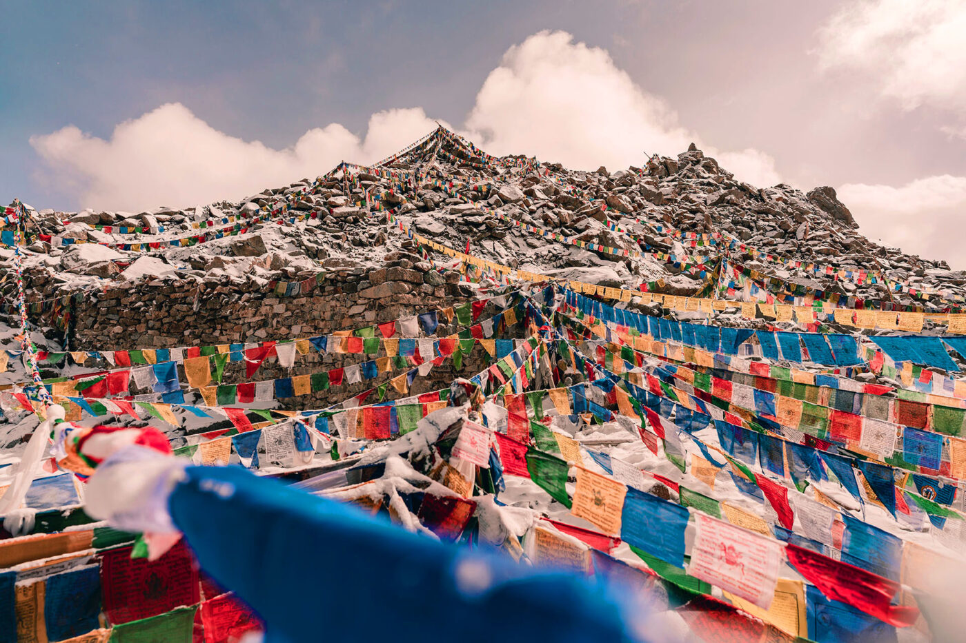 Lines and lines of multicoloured flags converge at the top of a mountain in the Ladakh Ranges.