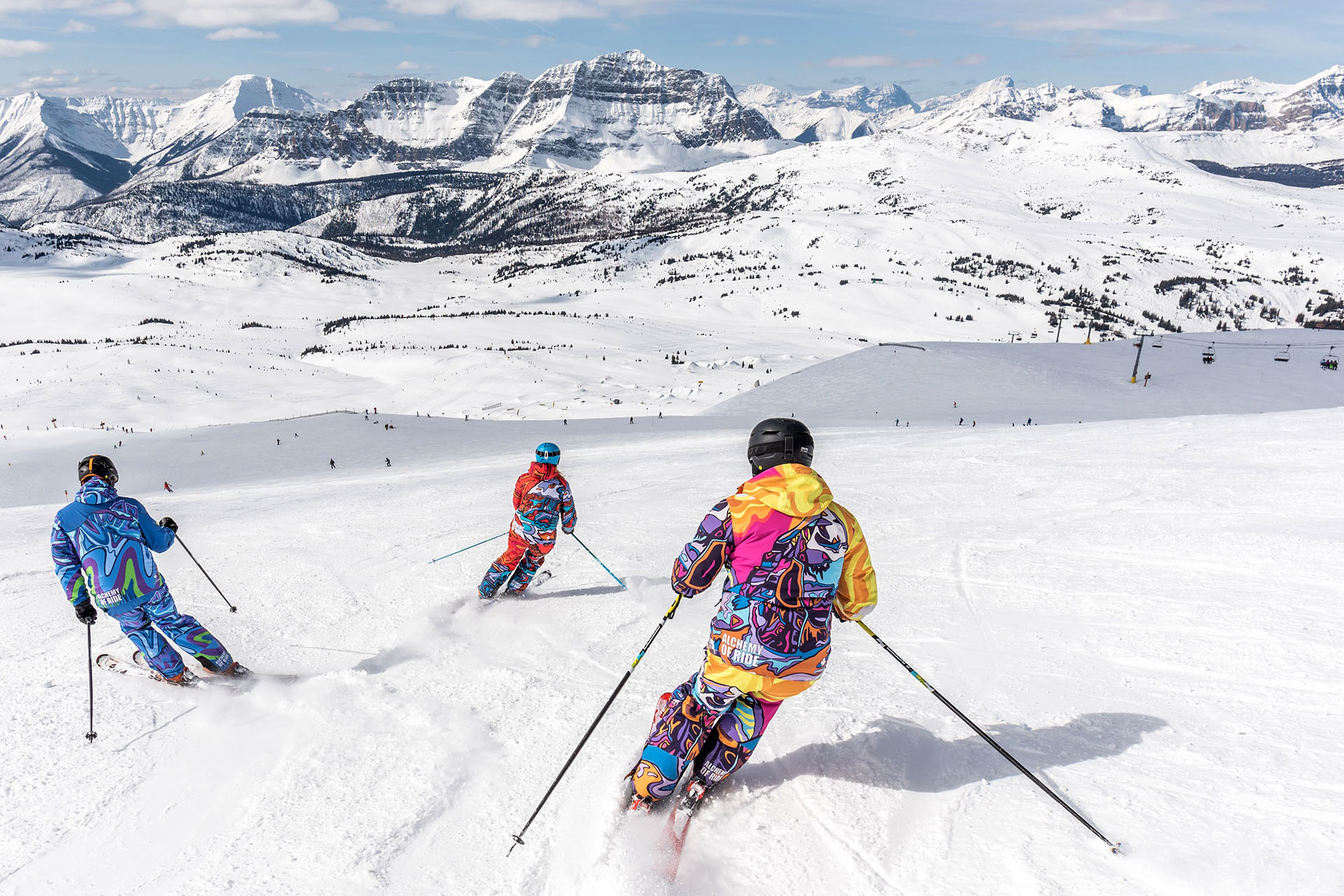 A few people skiing down the side of a snowy mountain.