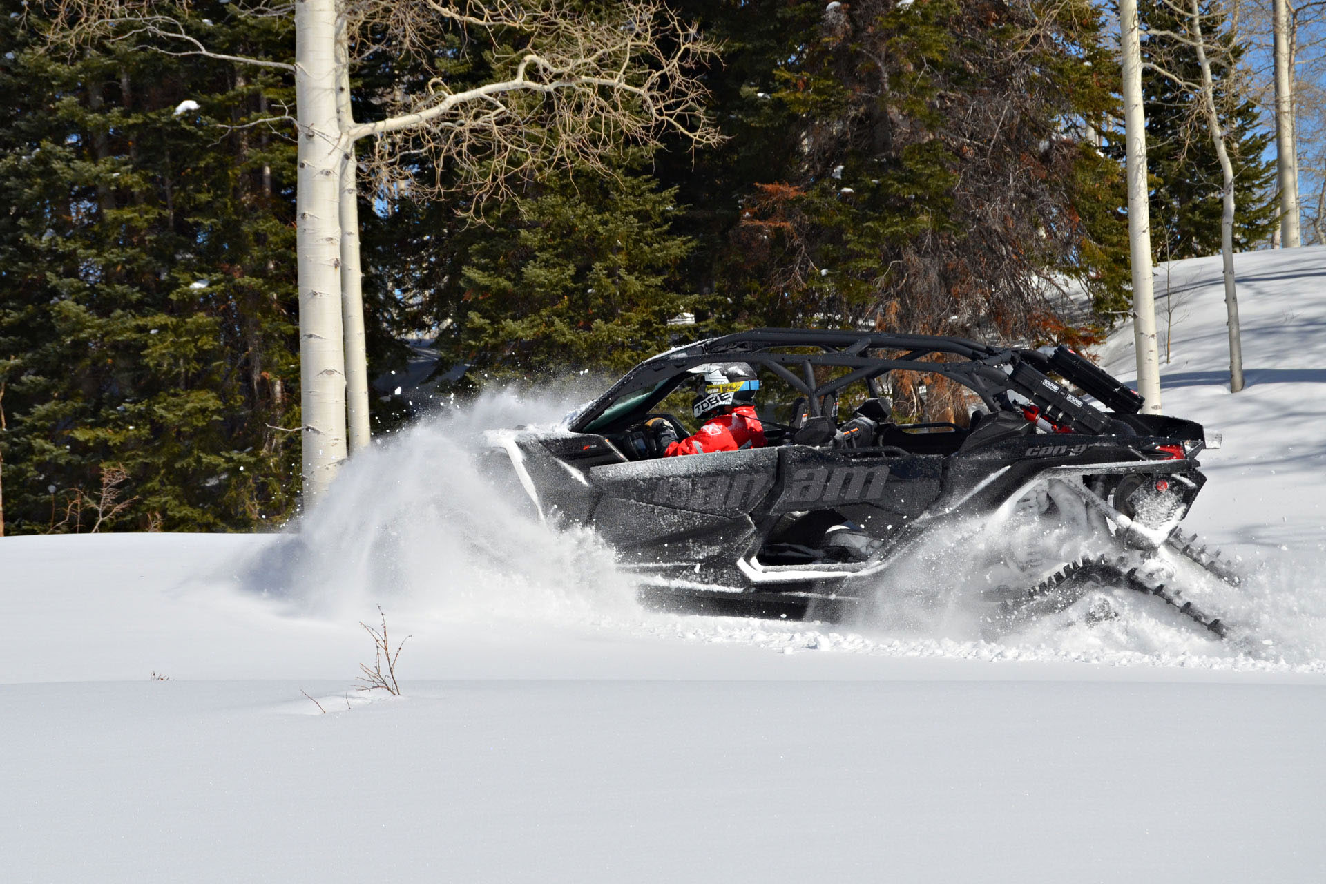A man driving a snow buggy through snow.