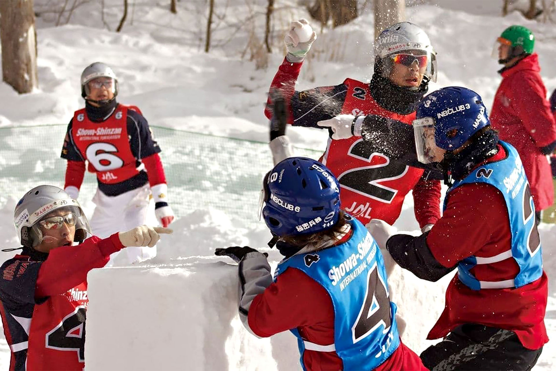 A group of Japanese people throwing snowballs at each other while playing Yukigassen.