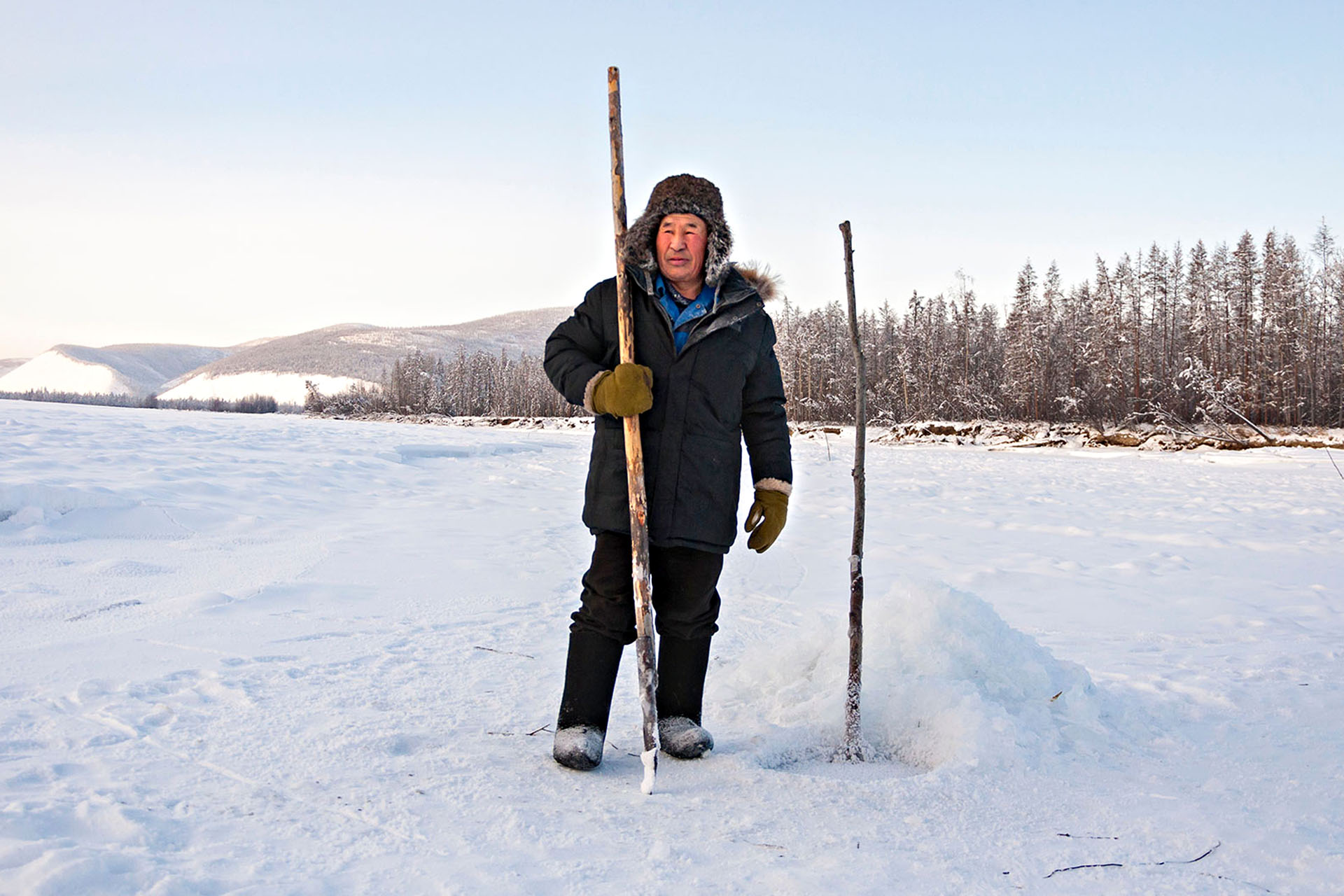 A local Russian fisherman standing on a frozen lake, about to go fishing.