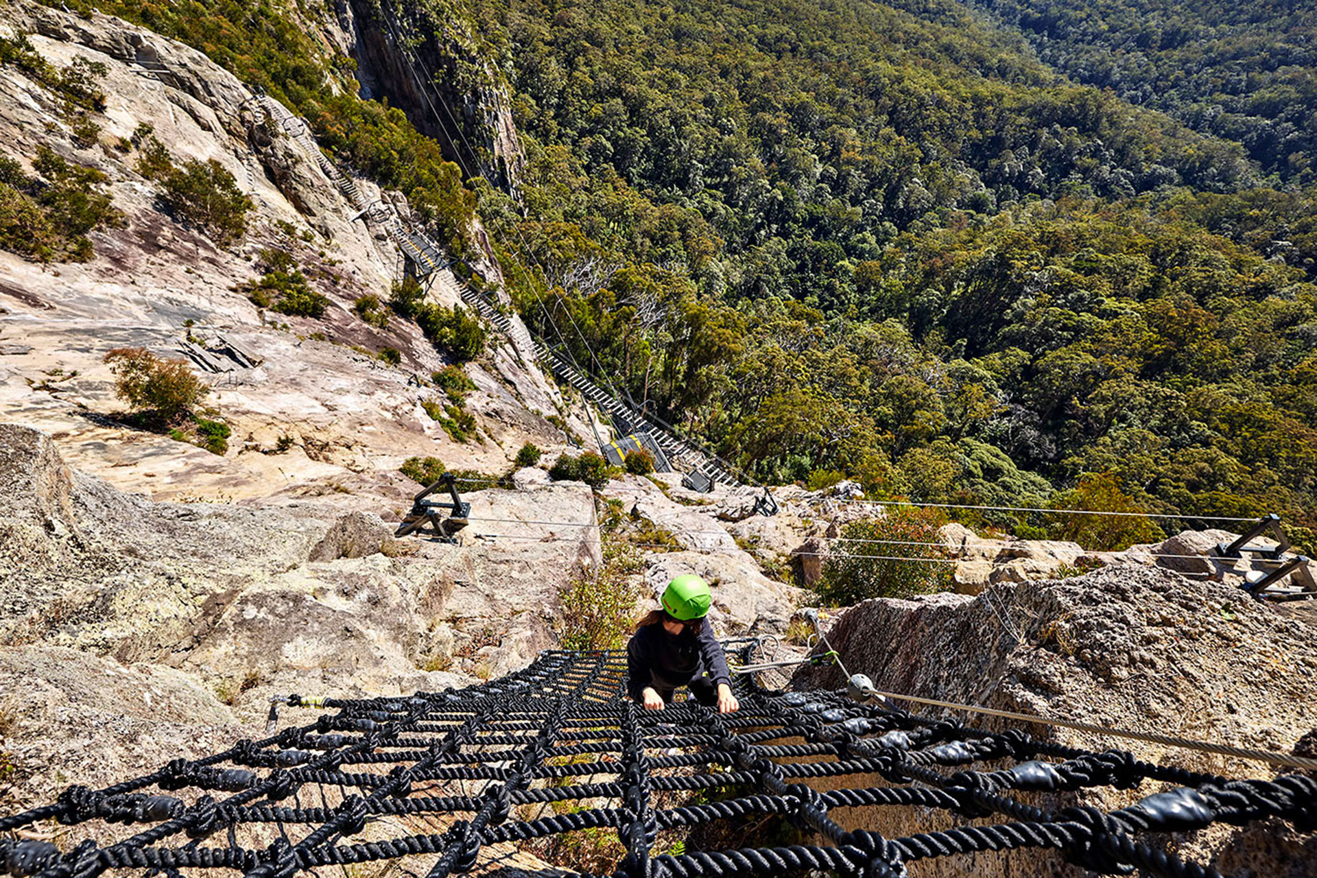 A woman does the via ferrata at Happitat Adventure Park in Lamington National Park.