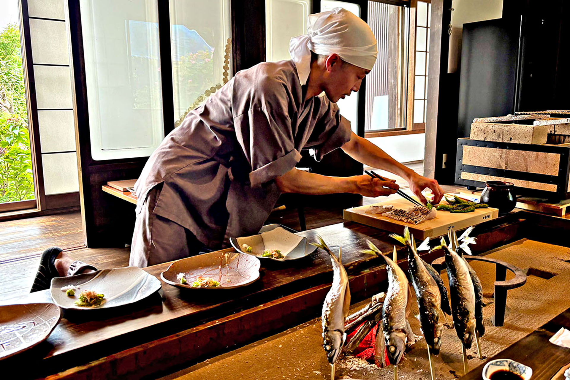 A chef preparing fresh ingredients to be cooked over charcoal.