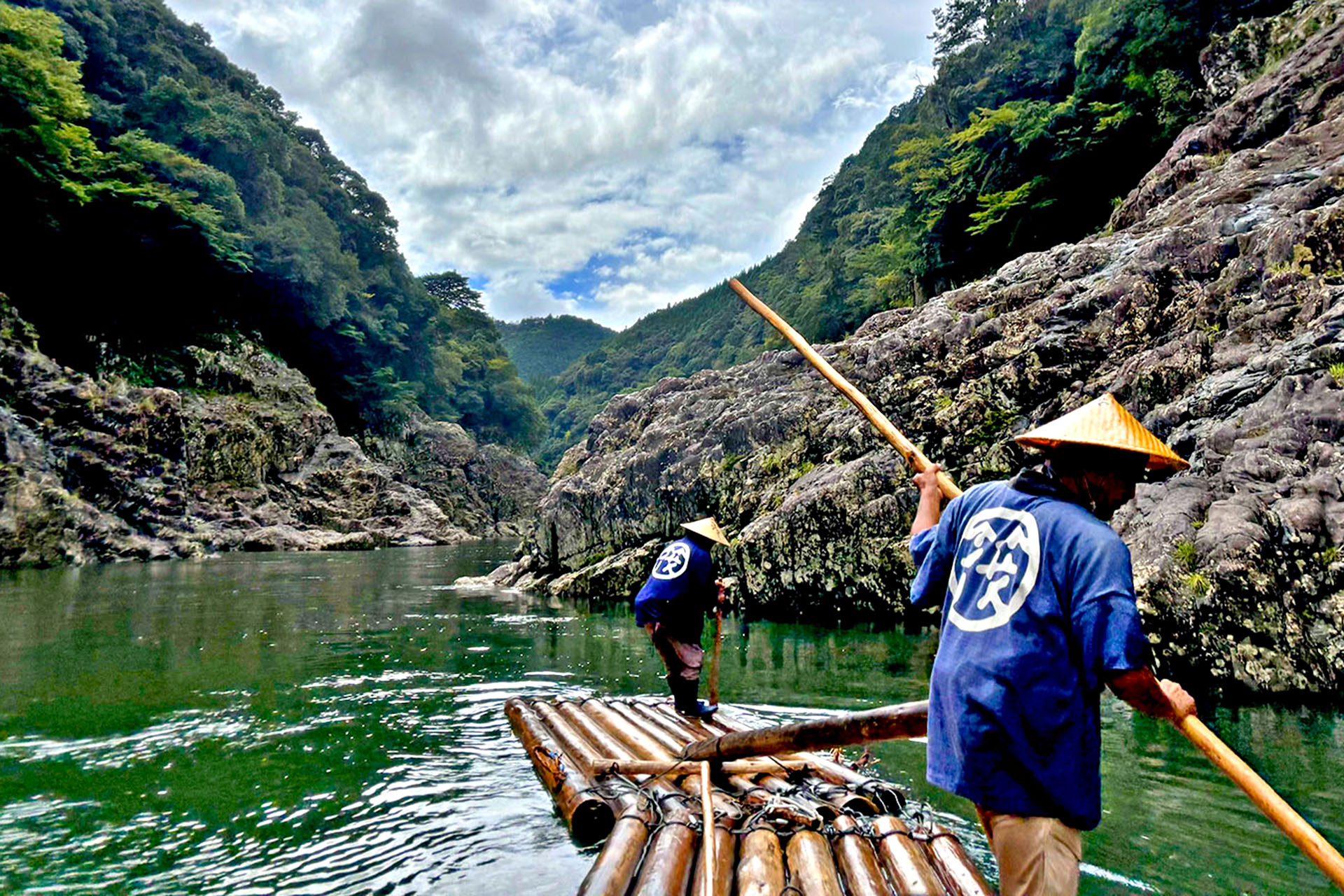 Two men working as traditional rafters along the Dorokyo Gorge in Japan.