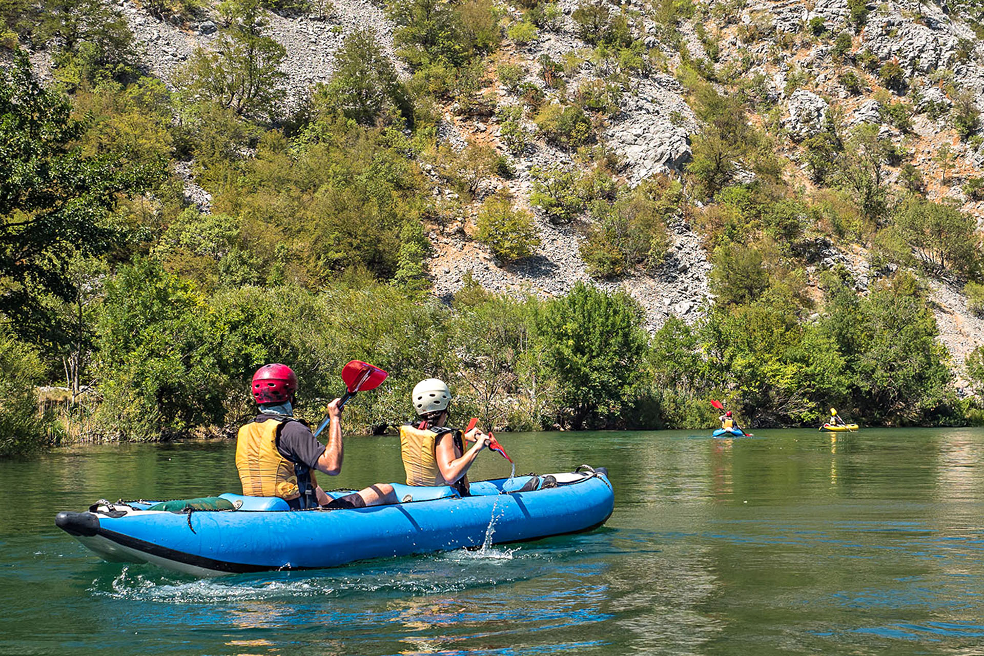 Kayakers paddling on Croatia's emerald Zrmanja River.