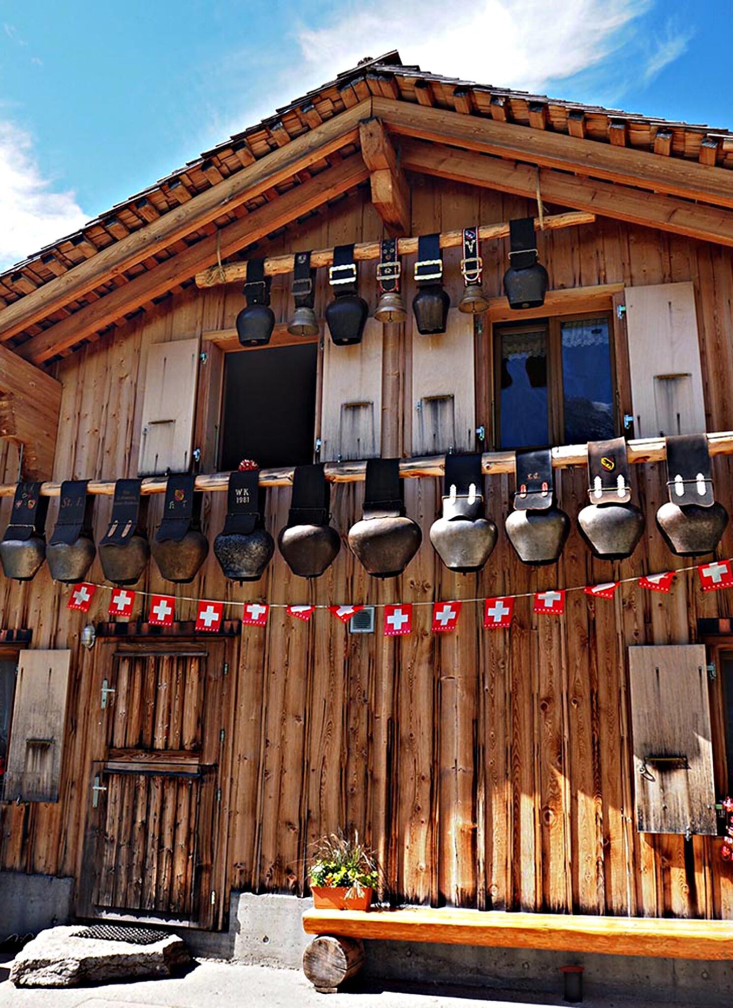Enormous cow bells hang from a mountain lodge.