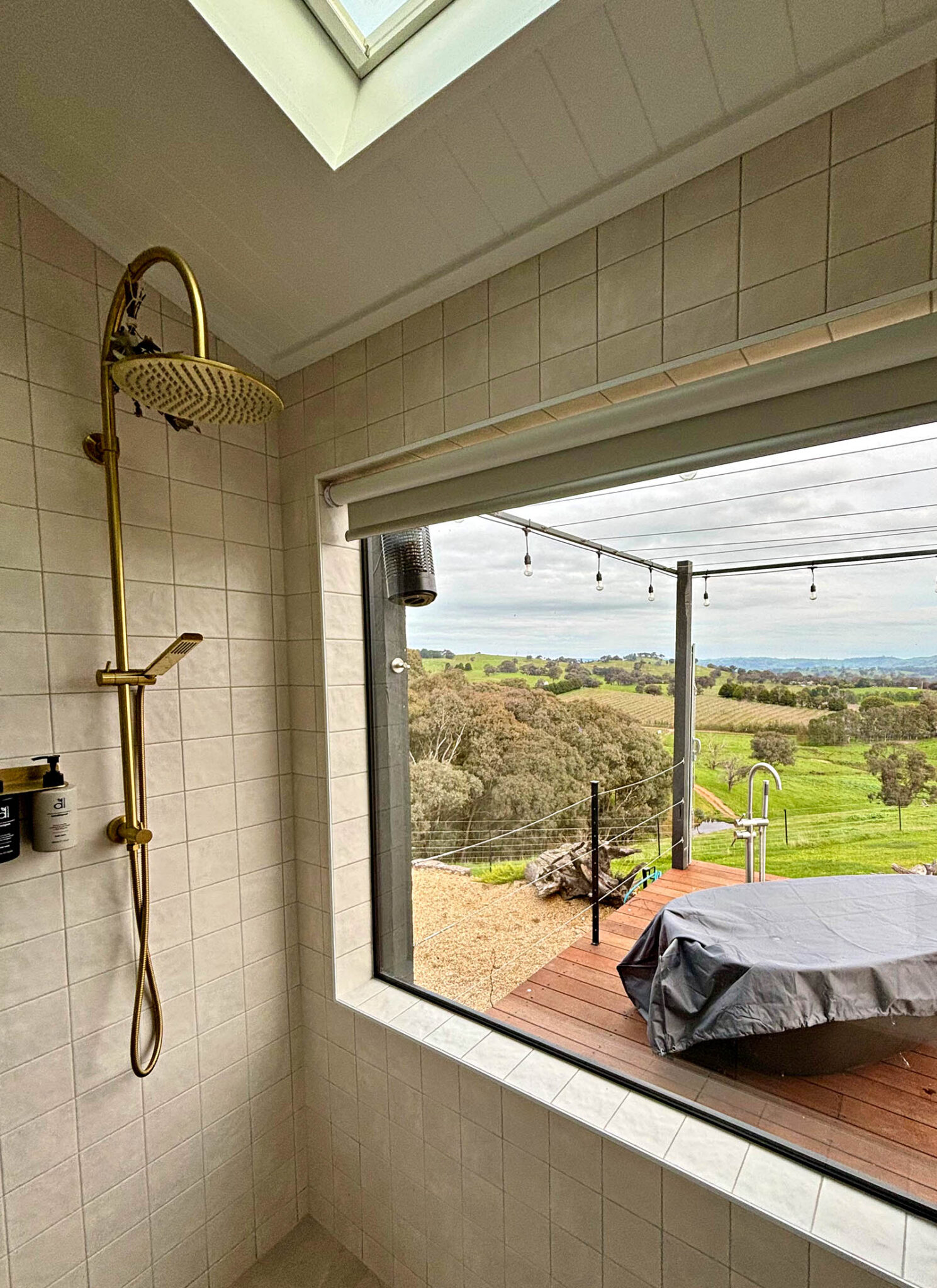 Bathroom at Karak Eco Lodge with rainfall shower and panoramic countryside views in Victoria High Country.