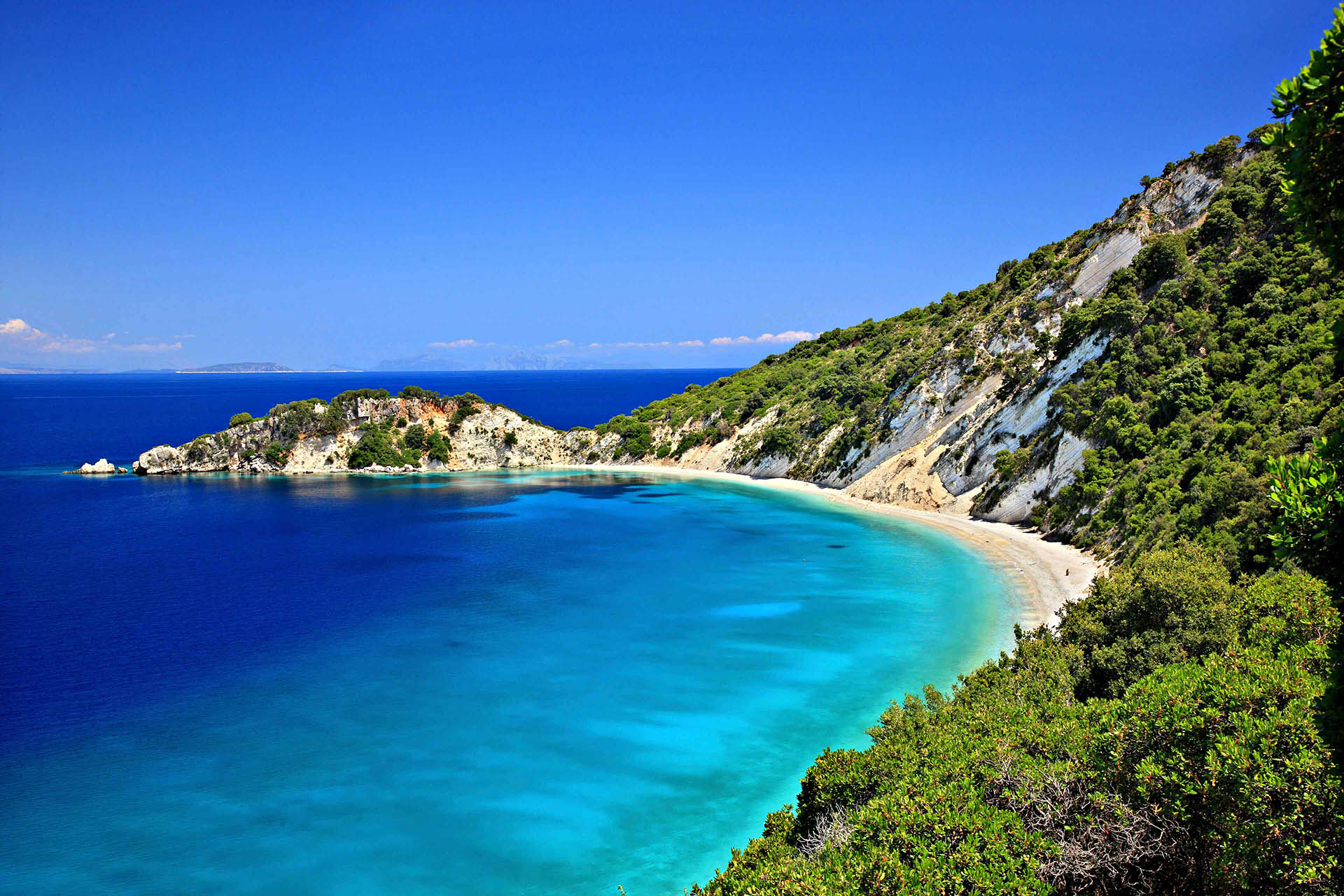 Hidden turquoise bay on a Greek island visited during the immersive Odyssey travel experience.