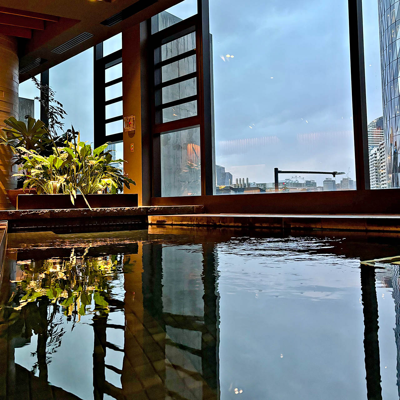 Indoor pool at 1 Hotel Melbourne with city views, floor-to-ceiling windows and tranquil atmosphere.