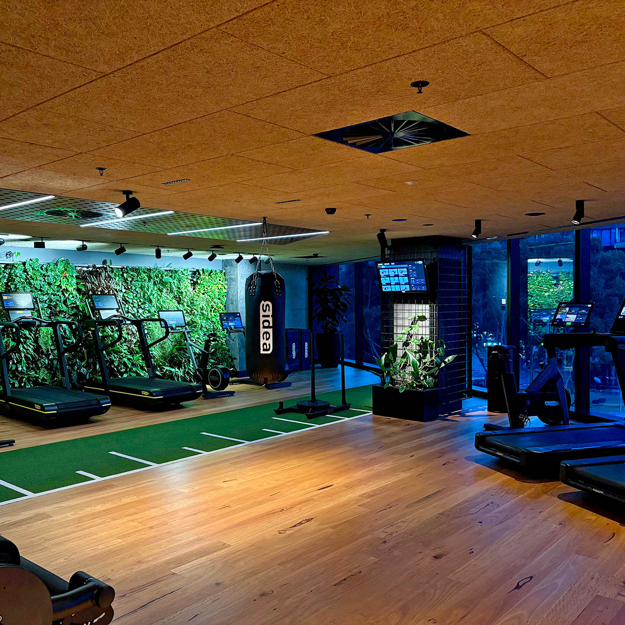 Fitness centre at 1 Hotel Melbourne featuring Technogym equipment, strength training area and living green wall.