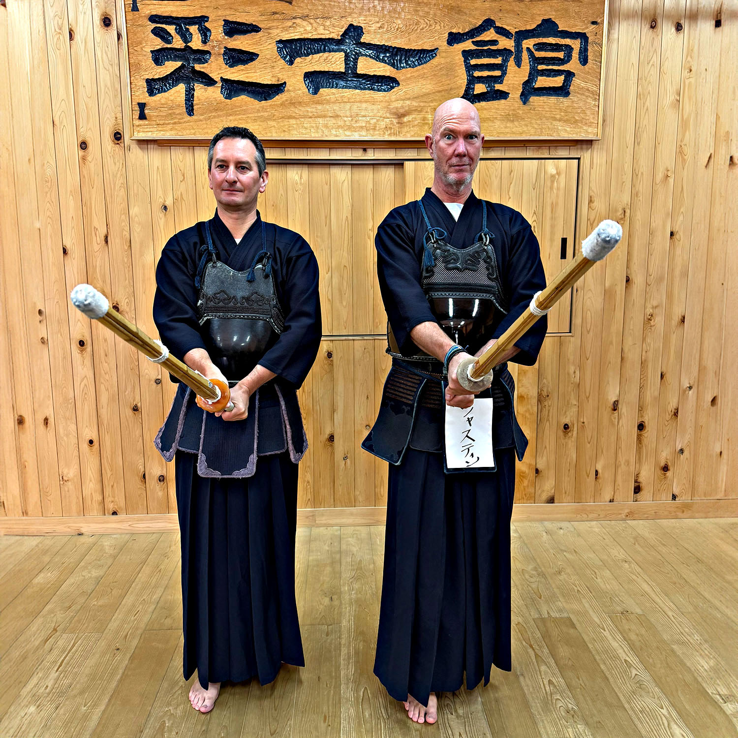 Travellers dressed in traditional kendo armour holding bamboo swords during a lesson in Kanazawa.