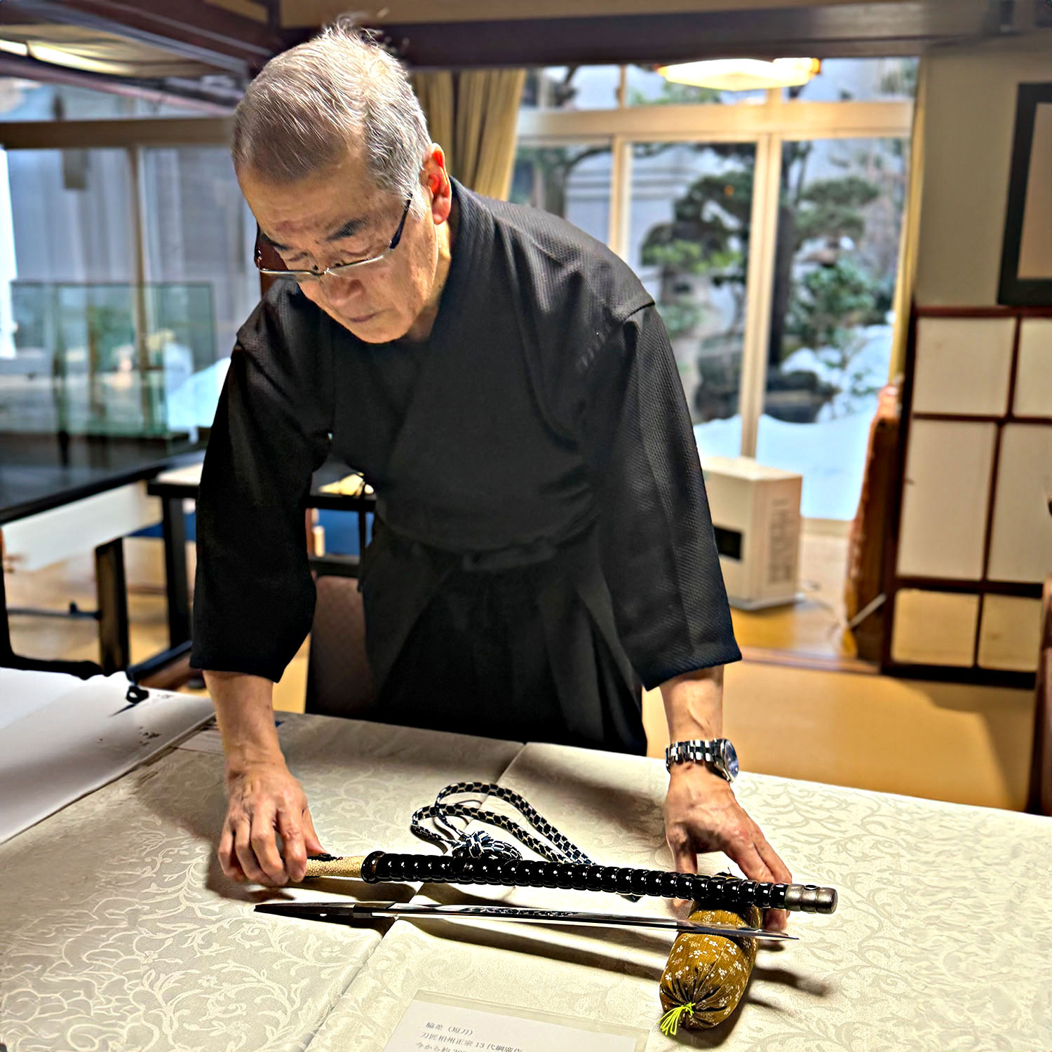 Japanese sword expert displaying a katana during a samurai experience in Kanazawa.