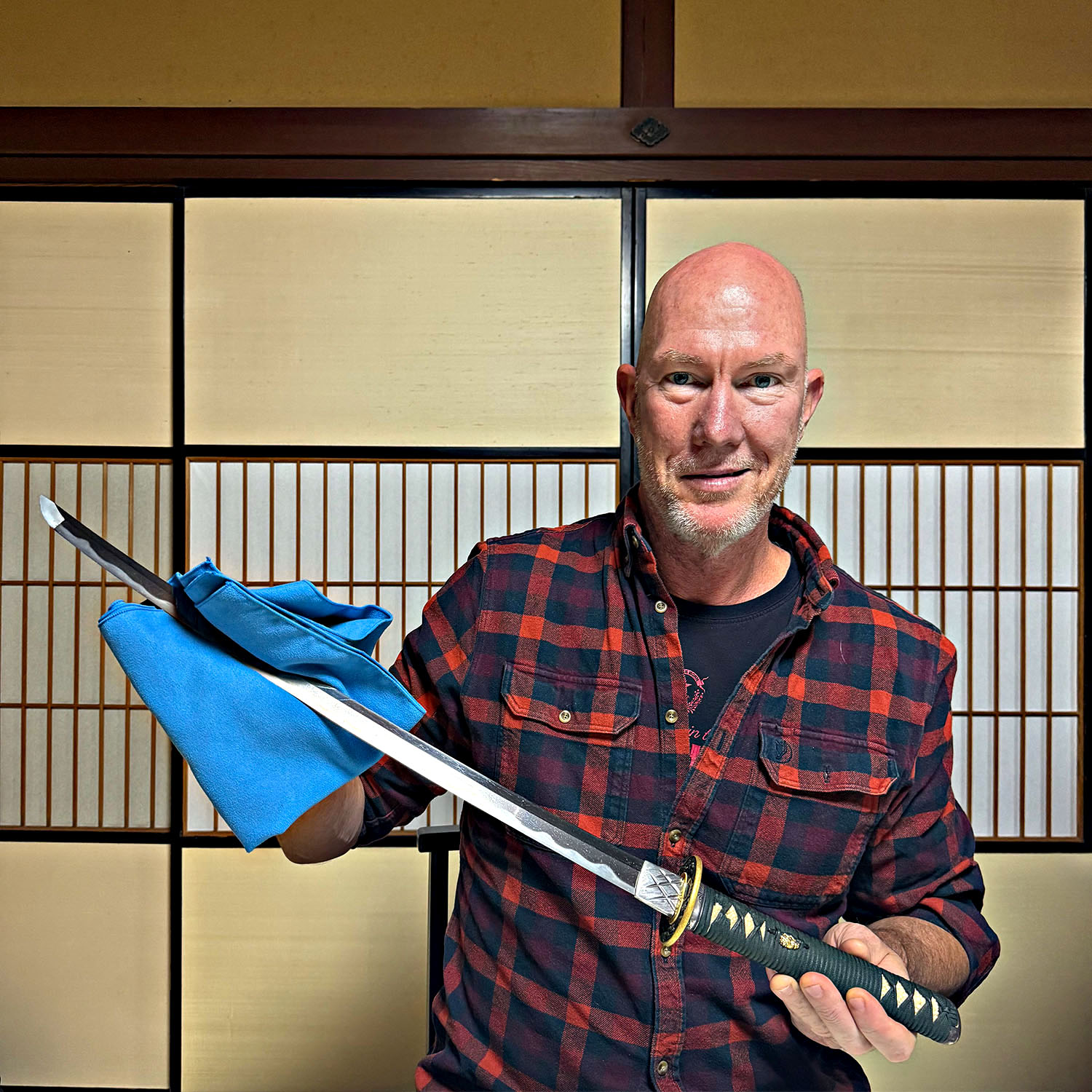 Traveller holding a traditional Japanese katana during a samurai sword experience in Kanazawa.
