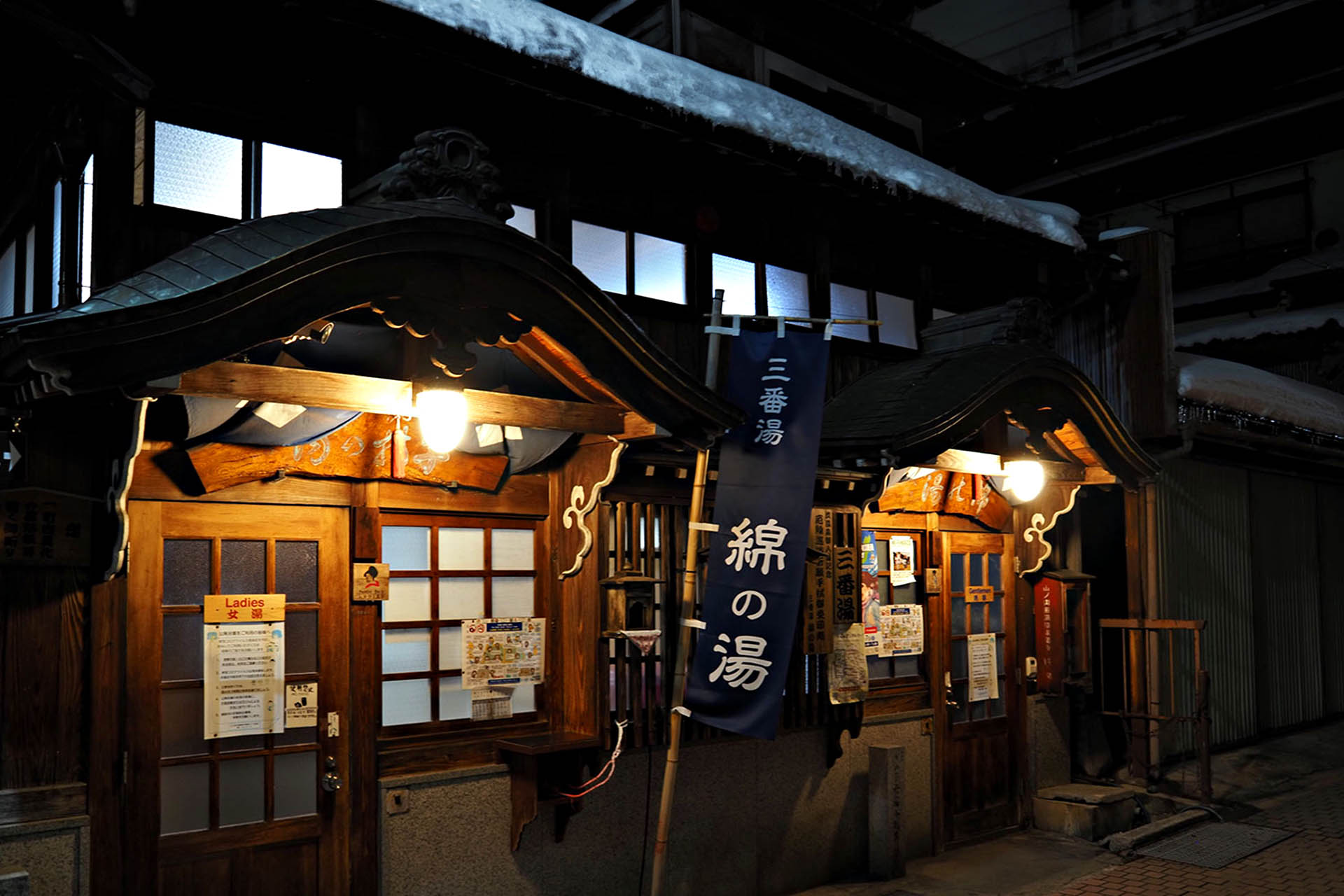 Traditional public bathhouses illuminated at night in Shibu Onsen, Nagano, Japan.