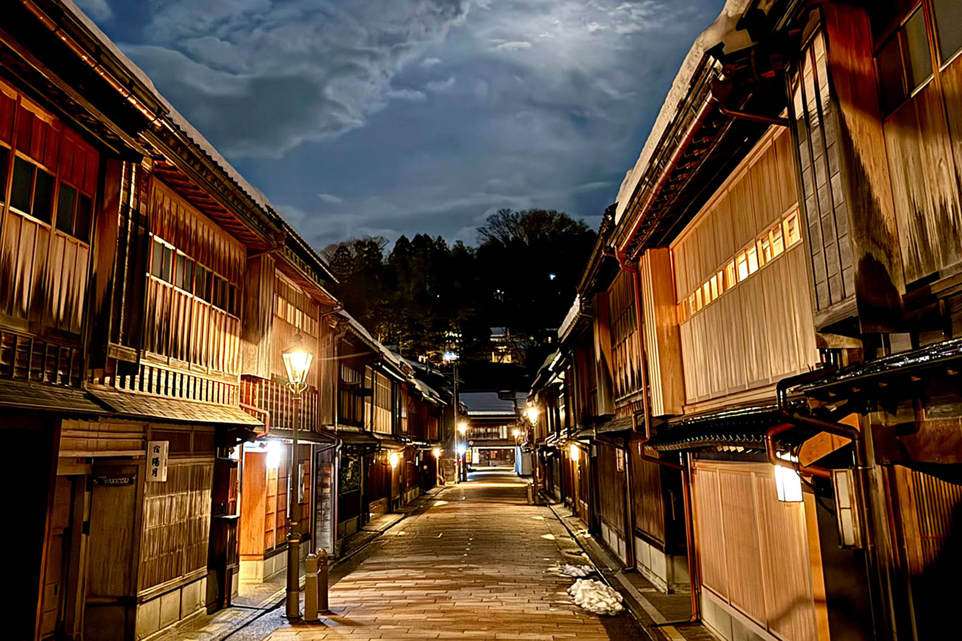 Historic wooden buildings lining the Higashi Chaya District in Kanazawa at night.