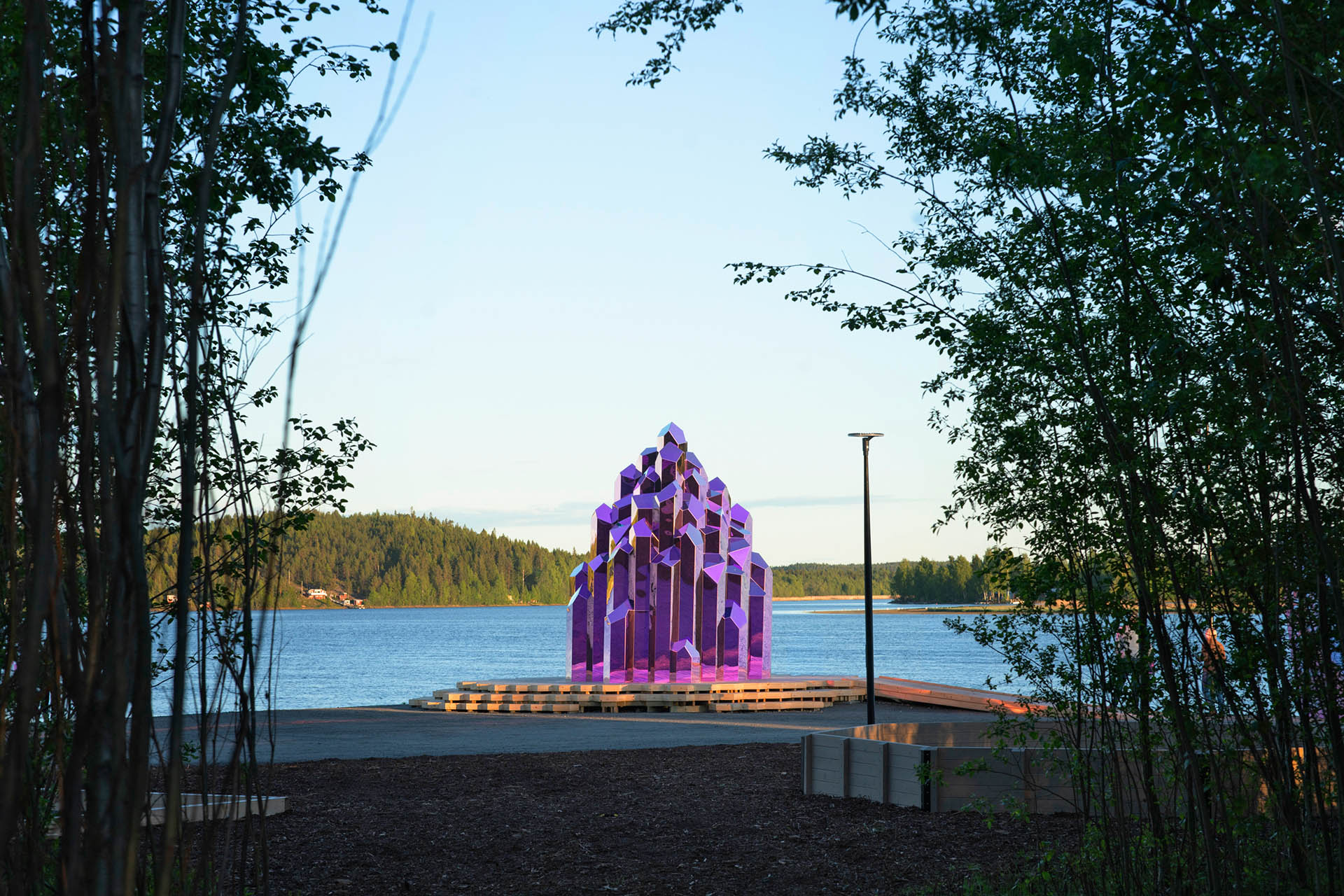 Pink mirrored Crystal Sauna beside the Skellefte River at WasteLand Climate Action Park in northern Sweden.