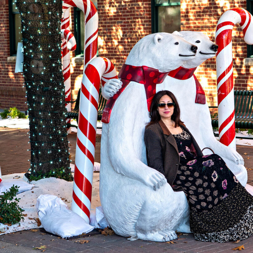 Woman poses with polar bear and giant candy cane Christmas decorations in Grapevine, Texas.