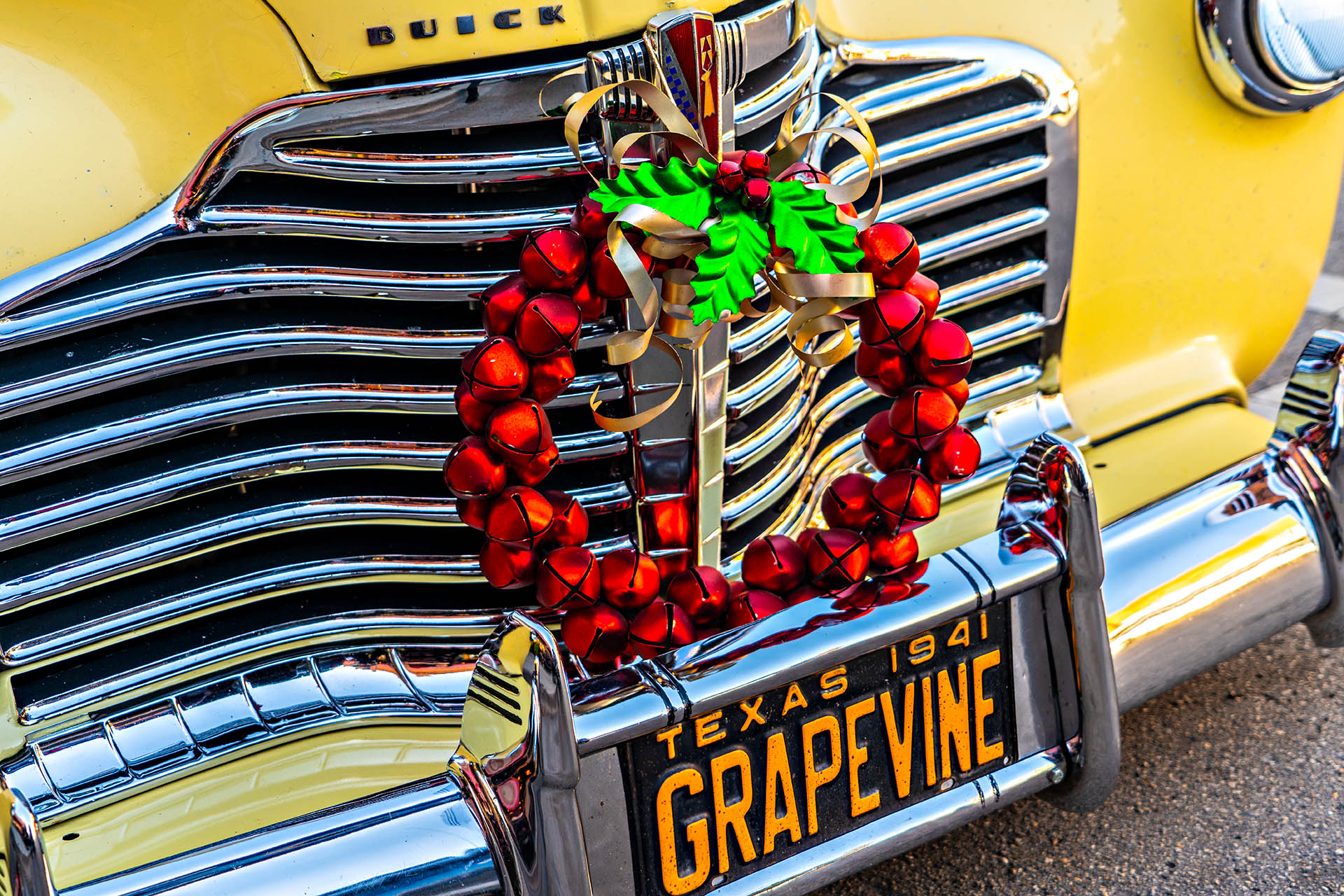 Vintage car decorated with a Christmas wreath and Grapevine Texas licence plate during Christmas in Grapevine, Texas.