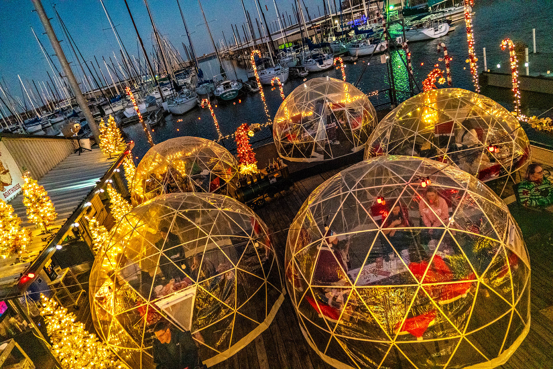 Private Christmas dining igloos glowing with festive lights overlooking the waterfront in Grapevine, Texas.