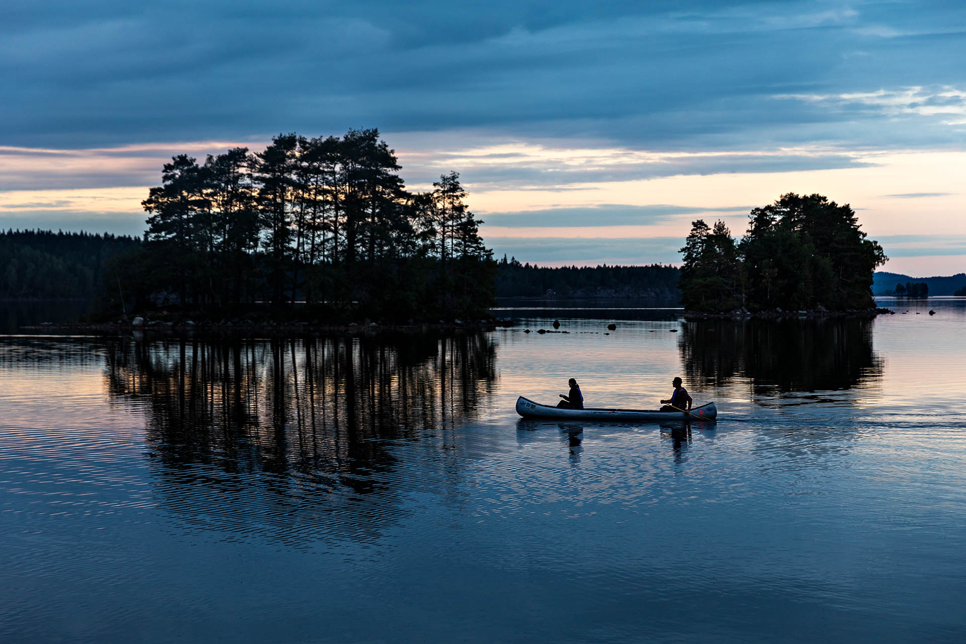 Travellers canoeing across a lake near Whitehorse in Yukon, Canada.