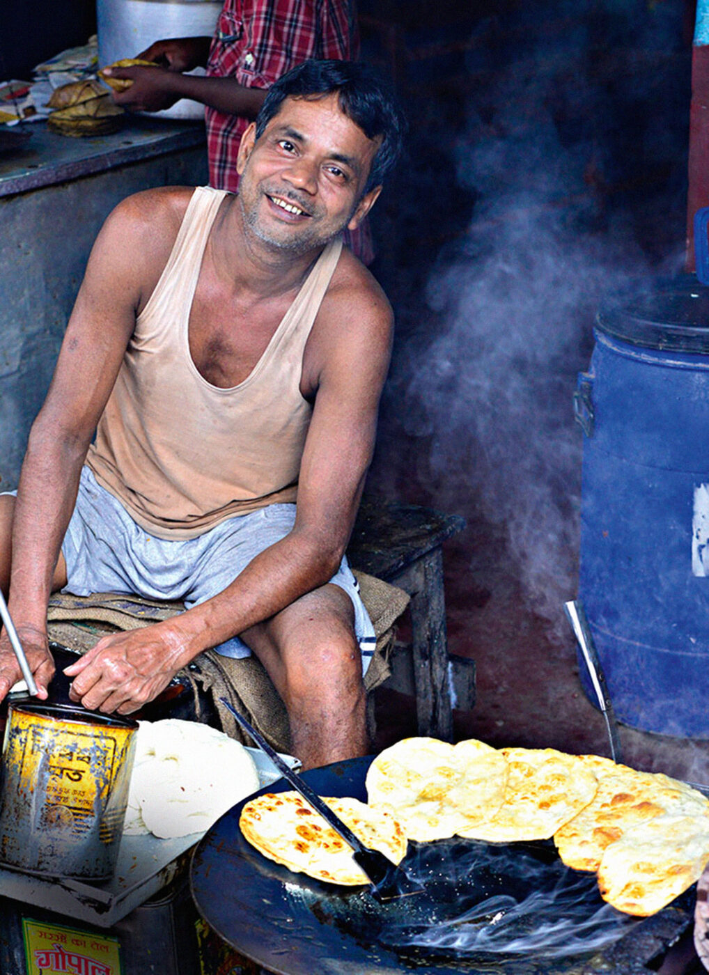 A street food vendor fries chapatis in Kalna market, on the banks of the Ganges.