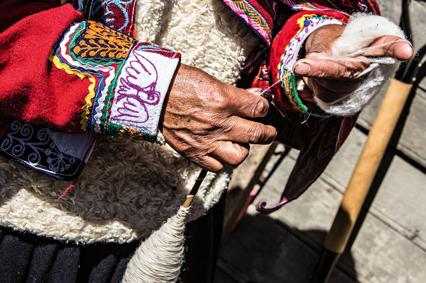Quechua woman spinning wool by hand in Peru’s Sacred Valley.