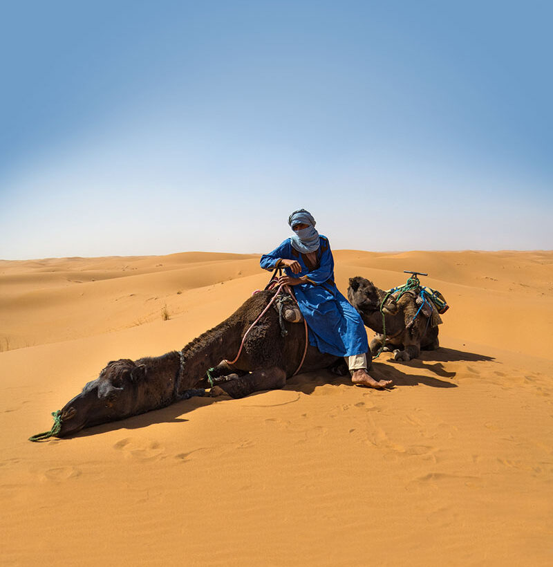 Stopping for a stretch on the camel trek across never-ending dunes.