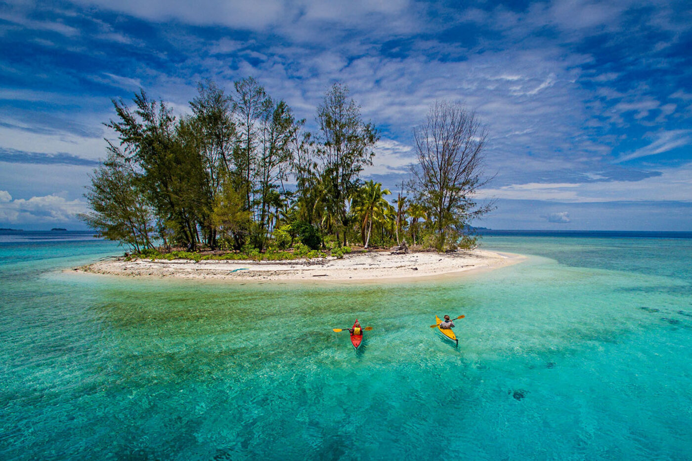 Kayakers approach a tiny island for a break.