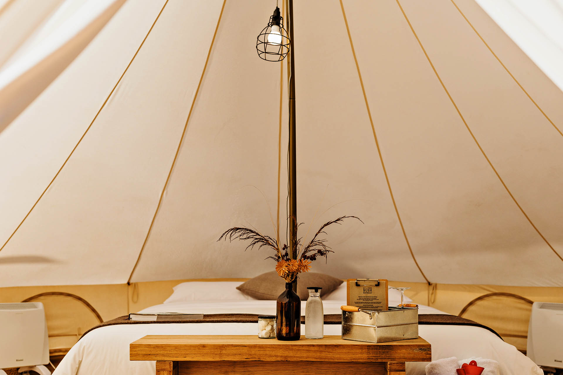 Inside a spacious glamping bell tent with a king-sized bed at Bay of Fires Bush Retreat in Tasmania.