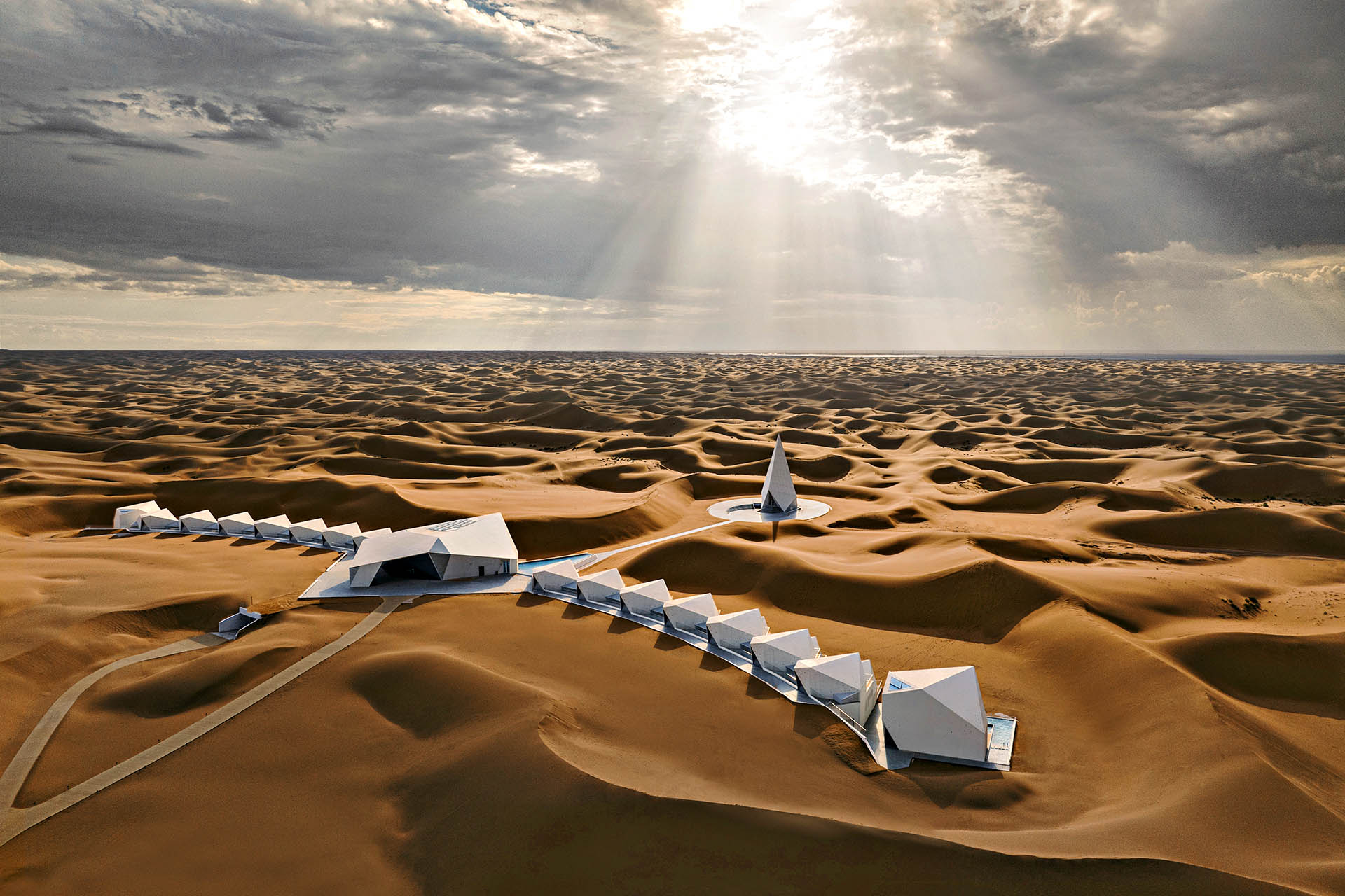 Aerial view of ZhongWei Desert Diamond Hotel surrounded by the vast sand dunes of the Tengger Desert in China.