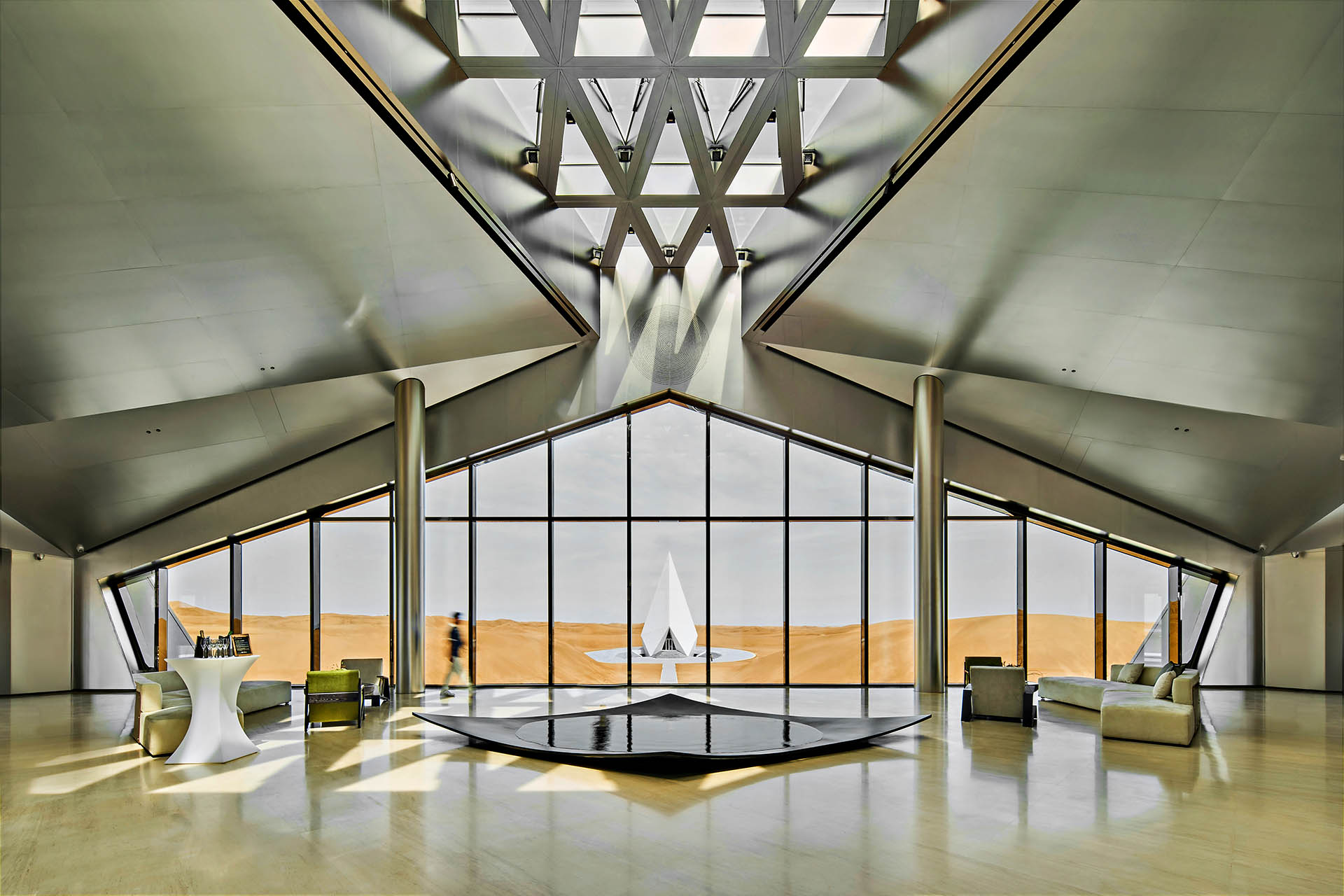 Geometric interior of ZhongWei Desert Diamond Hotel with floor-to-ceiling windows overlooking China’s Tengger Desert.