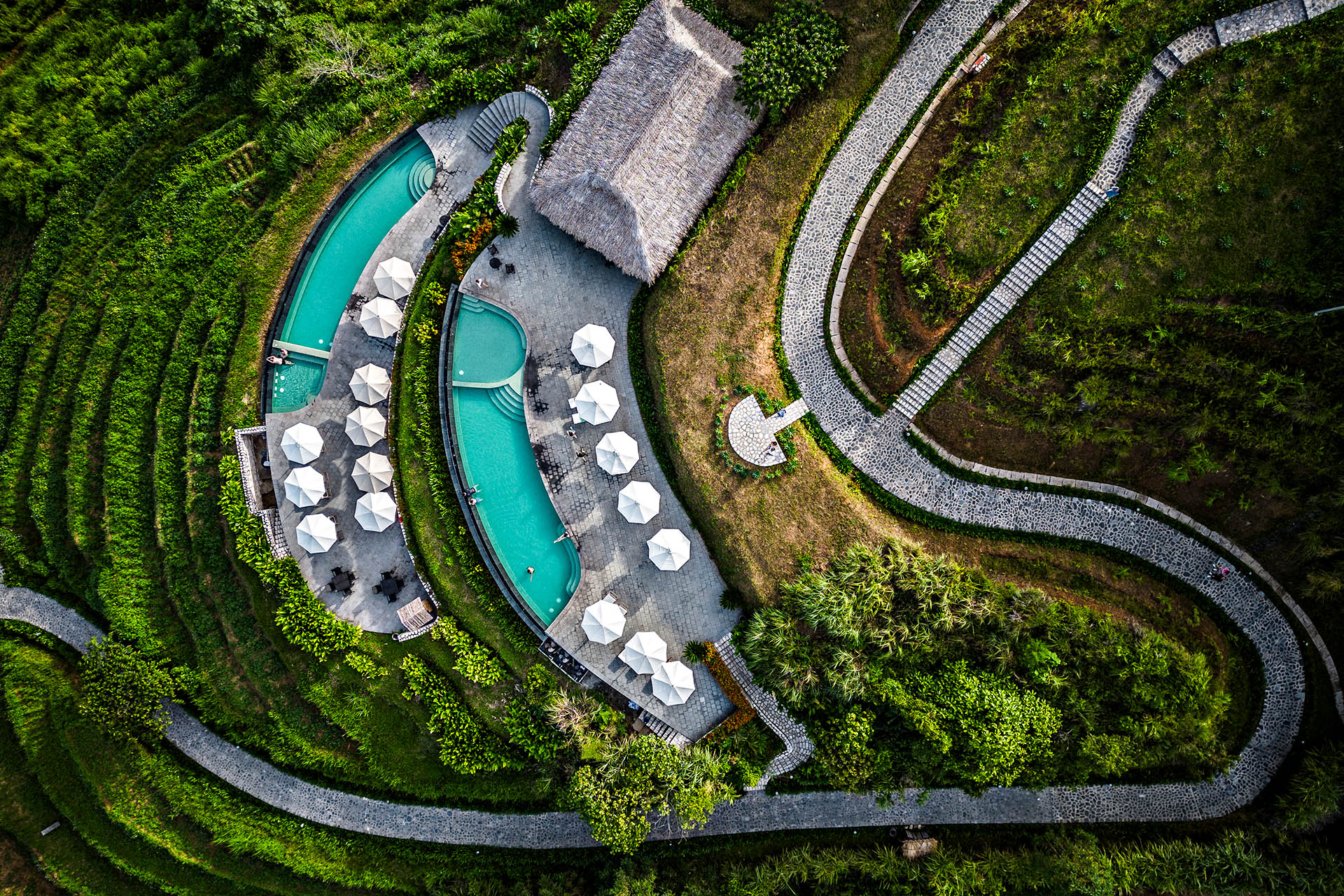 Aerial view of Topas Ecolodge Sapa’s infinity pools overlooking the green mountains and rice terraces of northern Vietnam.