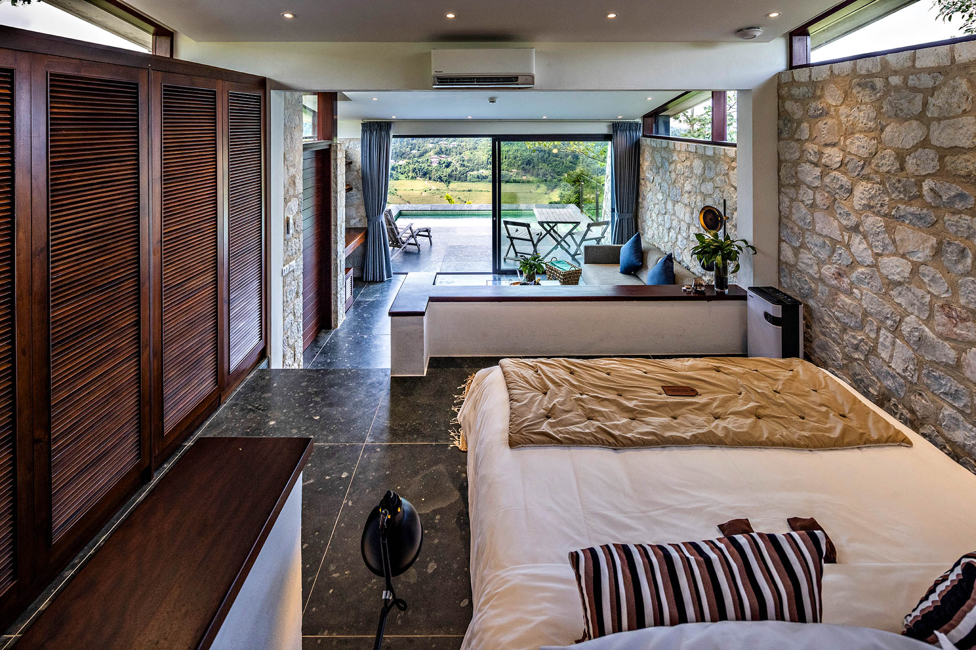Interior of a stone villa at Topas Ecolodge Sapa with a private terrace and pool overlooking the surrounding mountains.