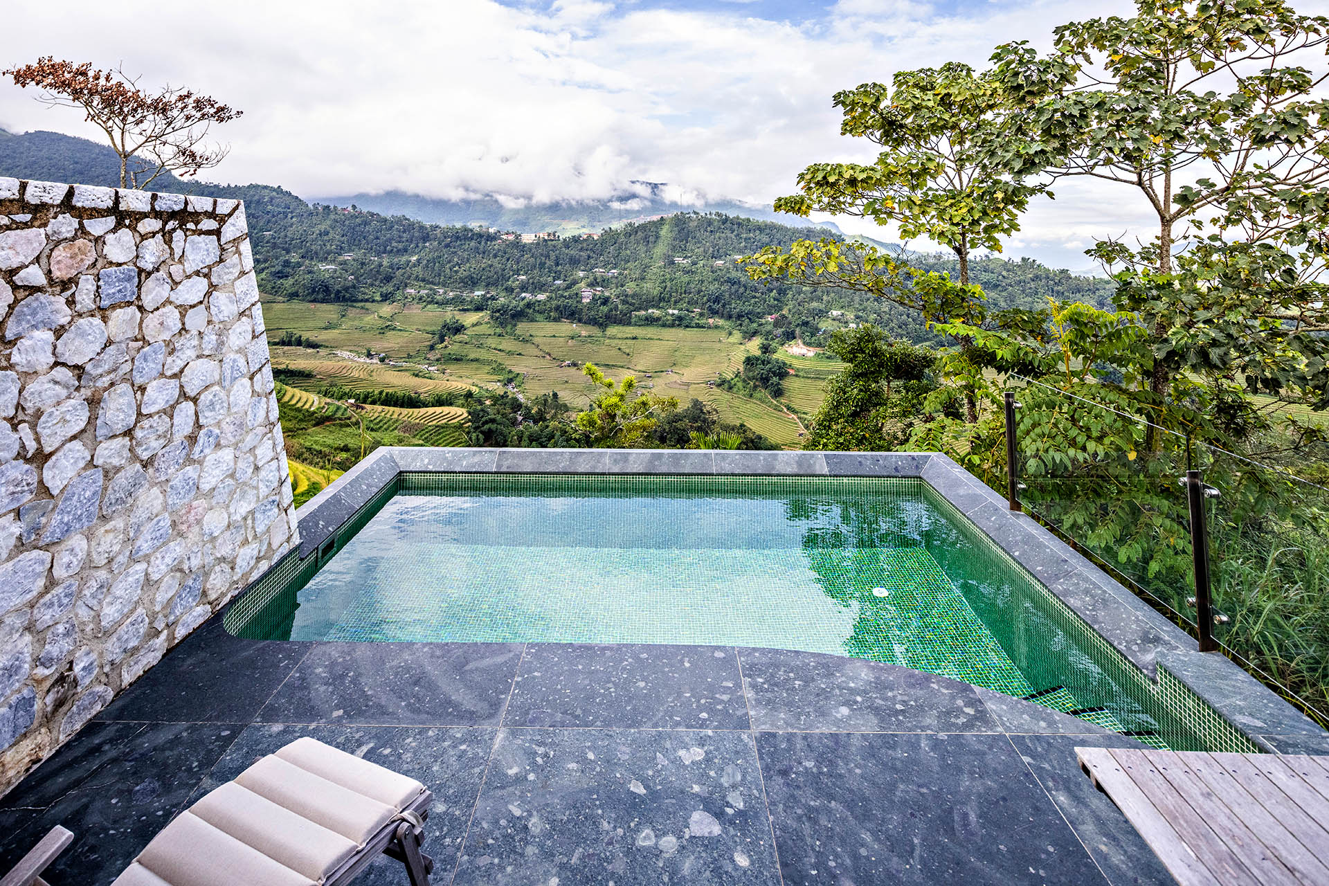 Private villa pool at Topas Ecolodge Sapa overlooking rice terraces and forested mountains in northern Vietnam.