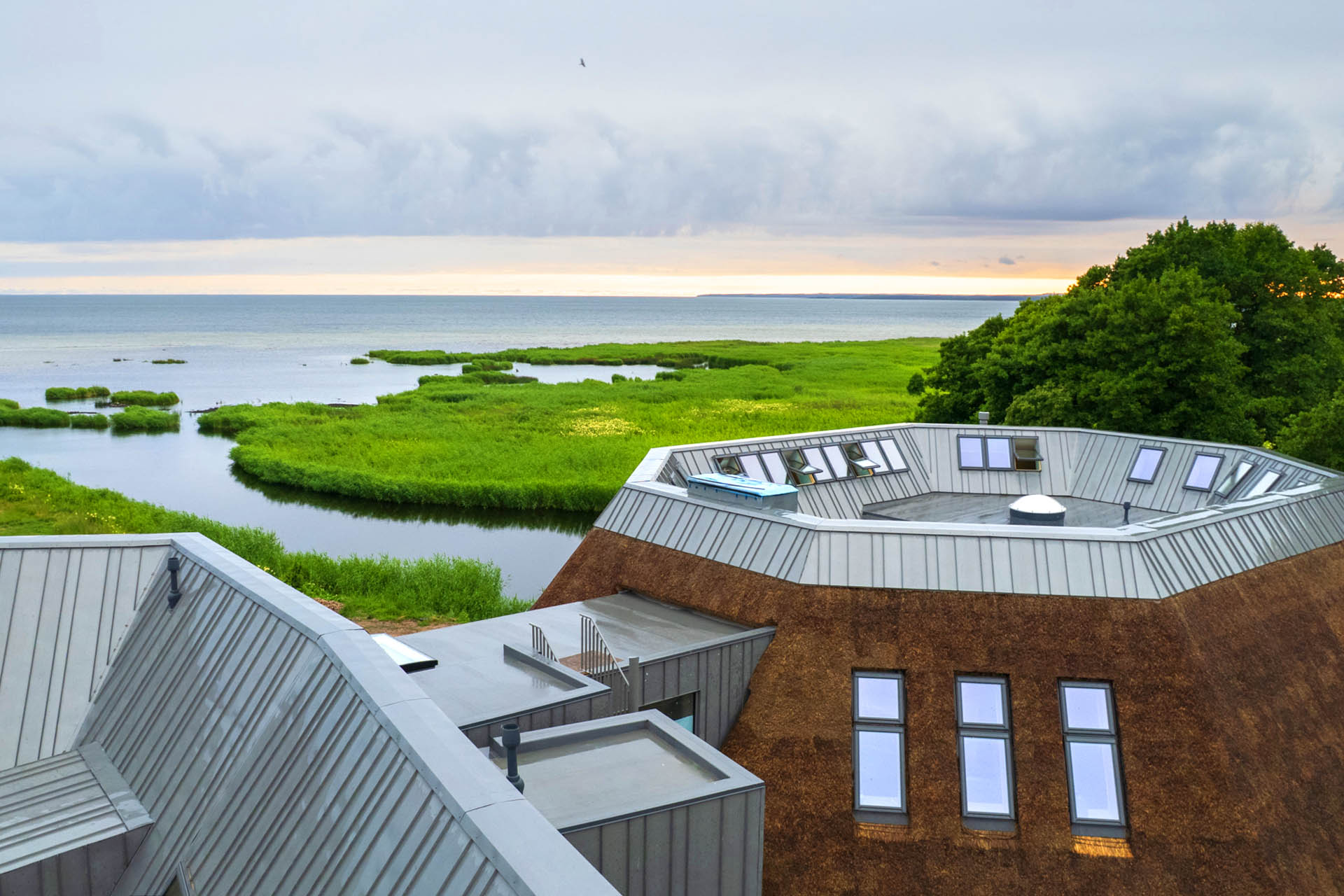 Thatched-roof buildings at Eha Retreat overlooking the Baltic Sea on Hiiumaa Island.