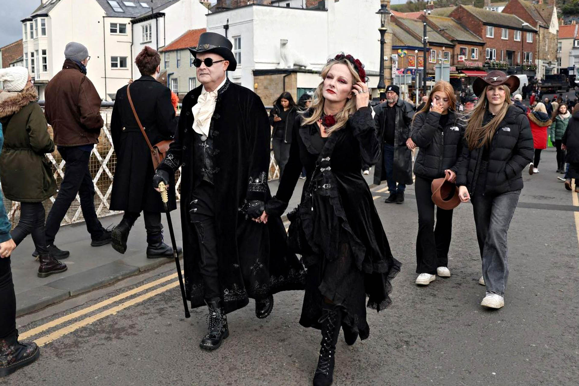 Goth festivalgoers dressed in elaborate black Victorian-inspired outfits at Whitby Goth Weekend in England.