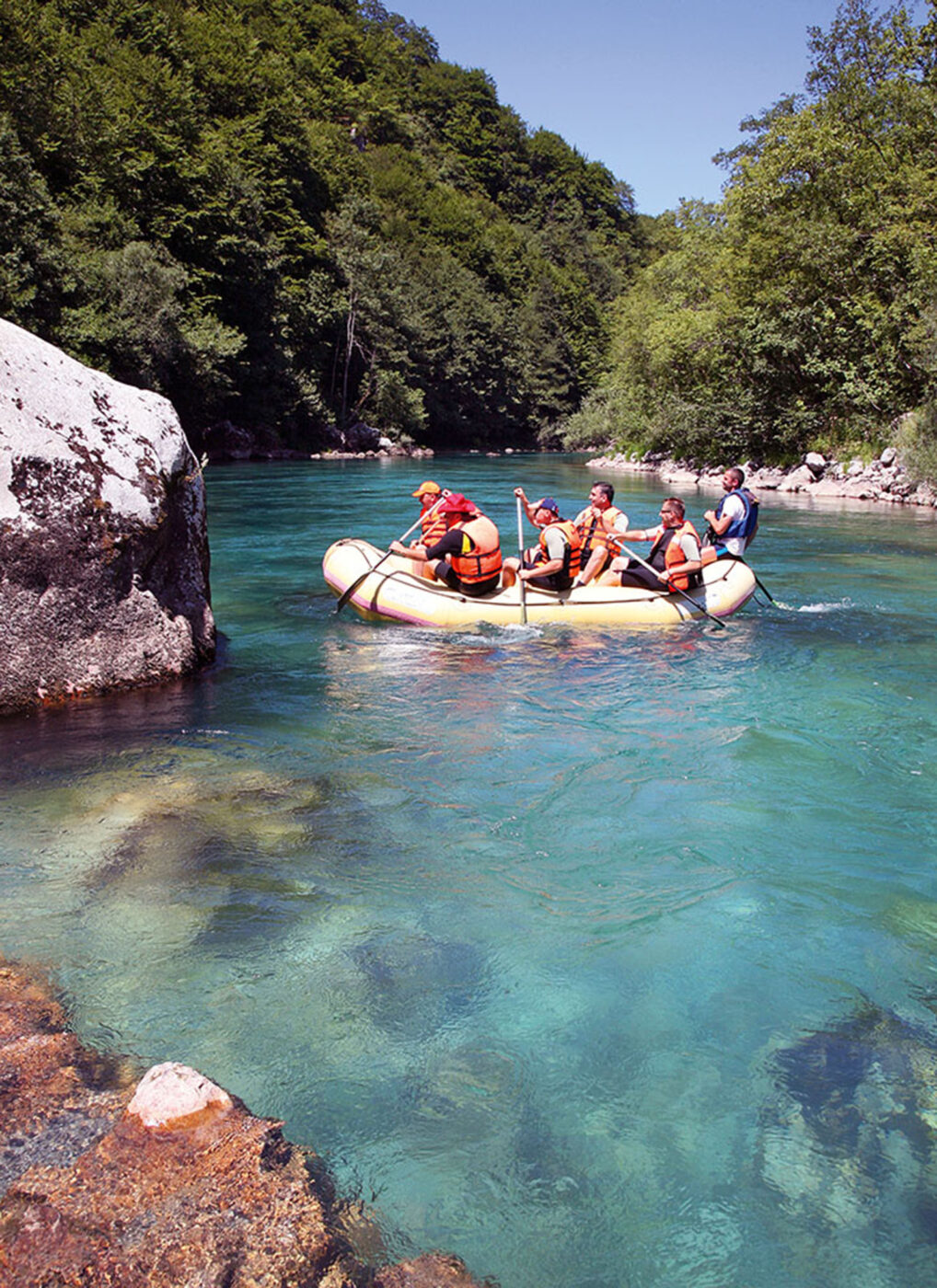 6 People in a blow up boat rowing through the water.