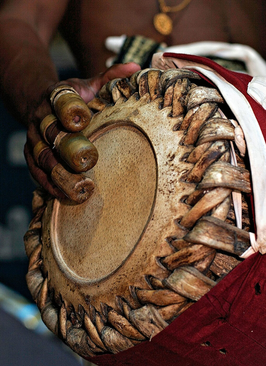 A close up of a drum, with a man's hand over the top.