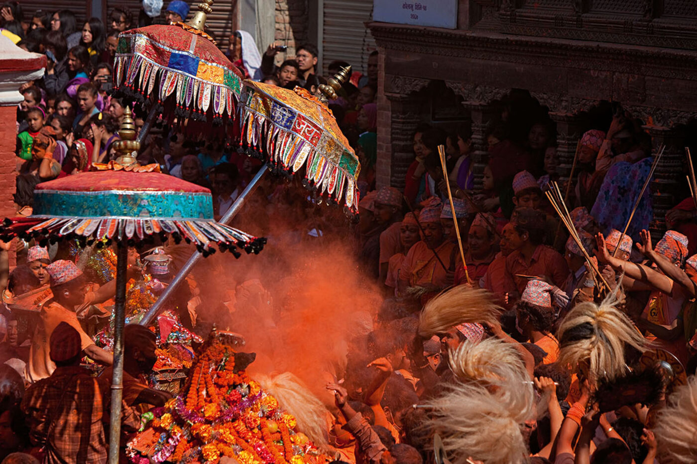 A big group of people celebrating. The air is filled with orange smoke.