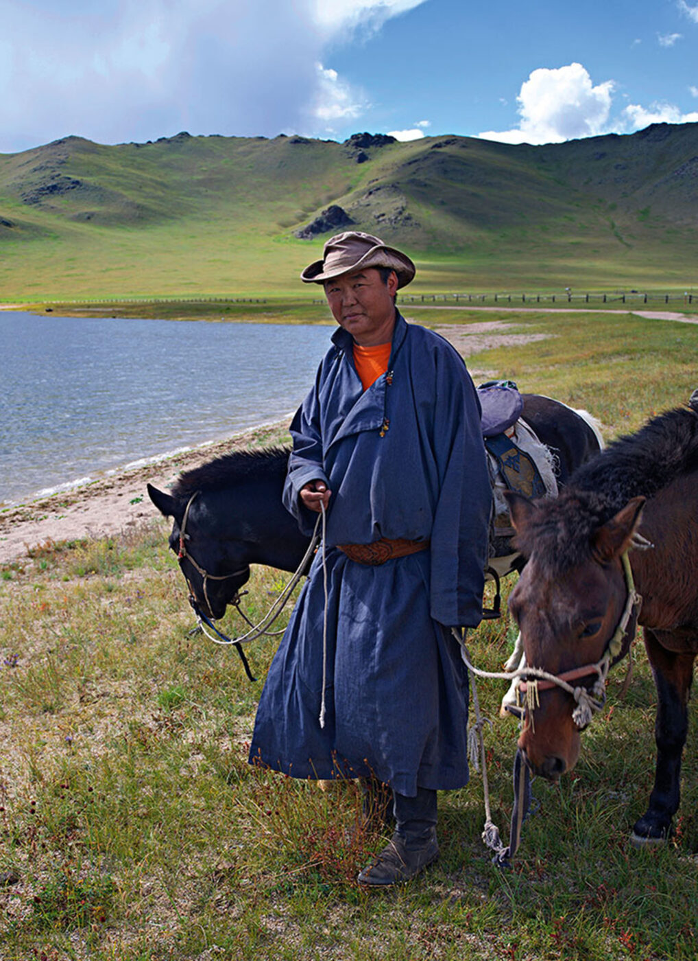 A man standing with two horses.
