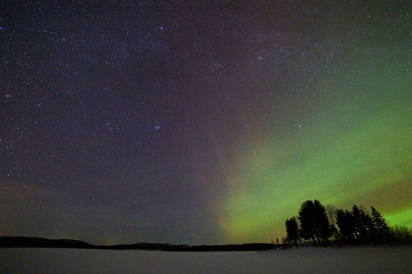 A big night sky with hues of green, the aurora borealis.
